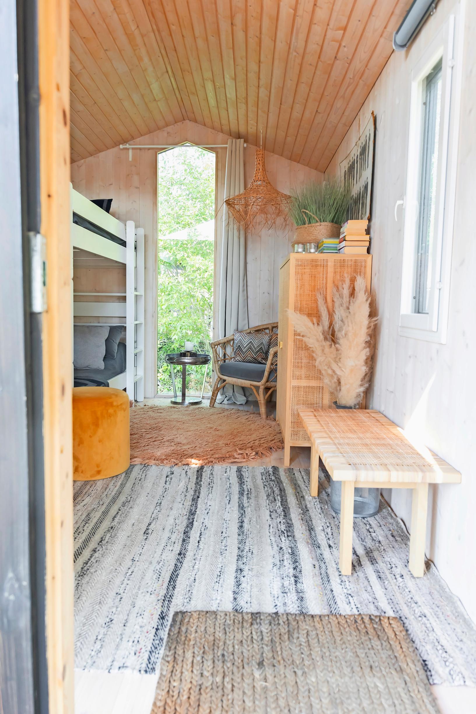a bunk bed, rugs, a wooden bench, a chair, a beanbag, and a cabinet