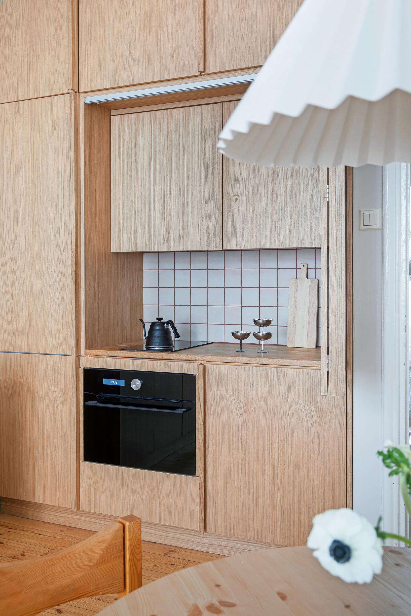In the wood-toned small kitchen, a combination oven works as a microwave too