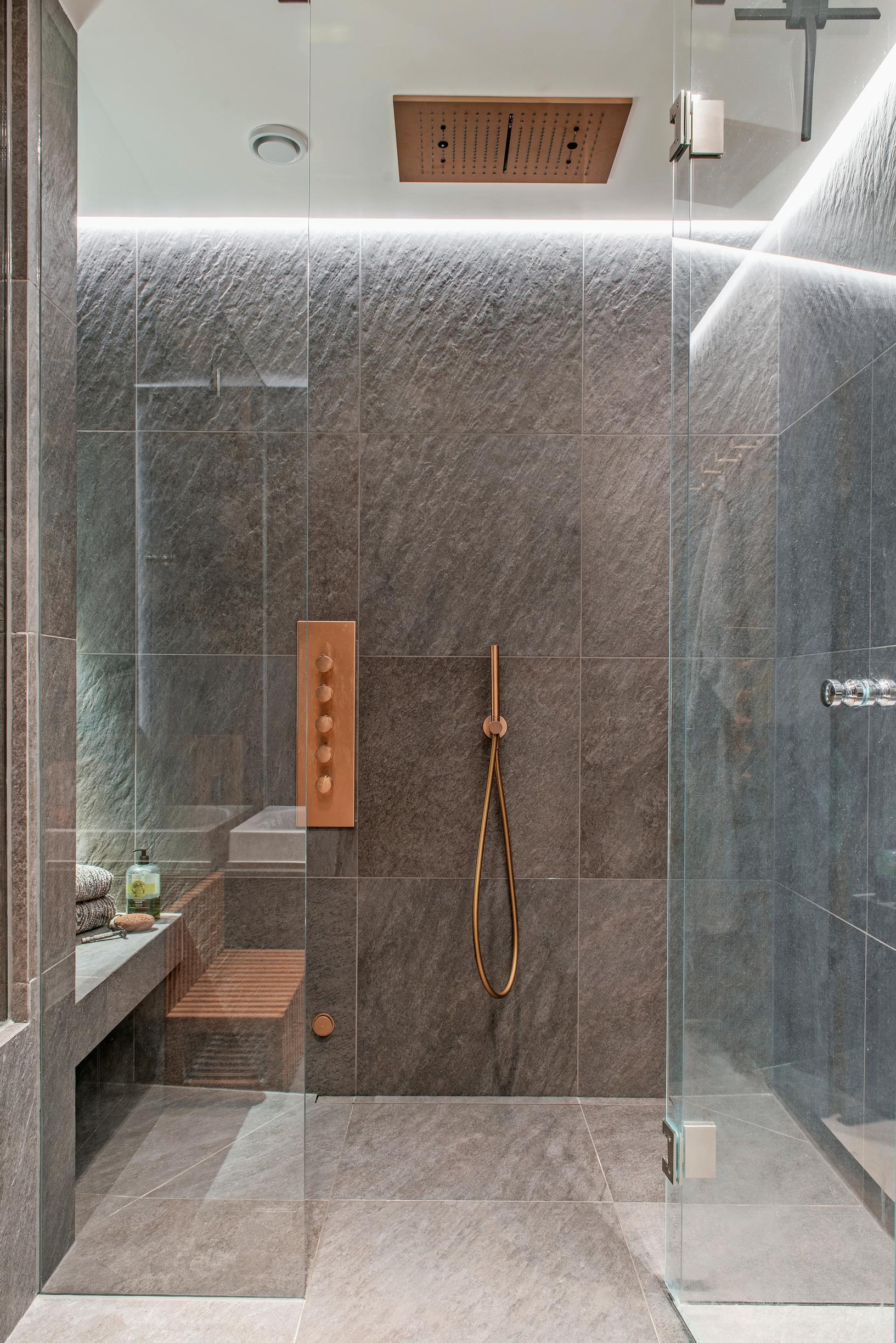 The dark, stone-like tiling creates atmosphere in the bath area.