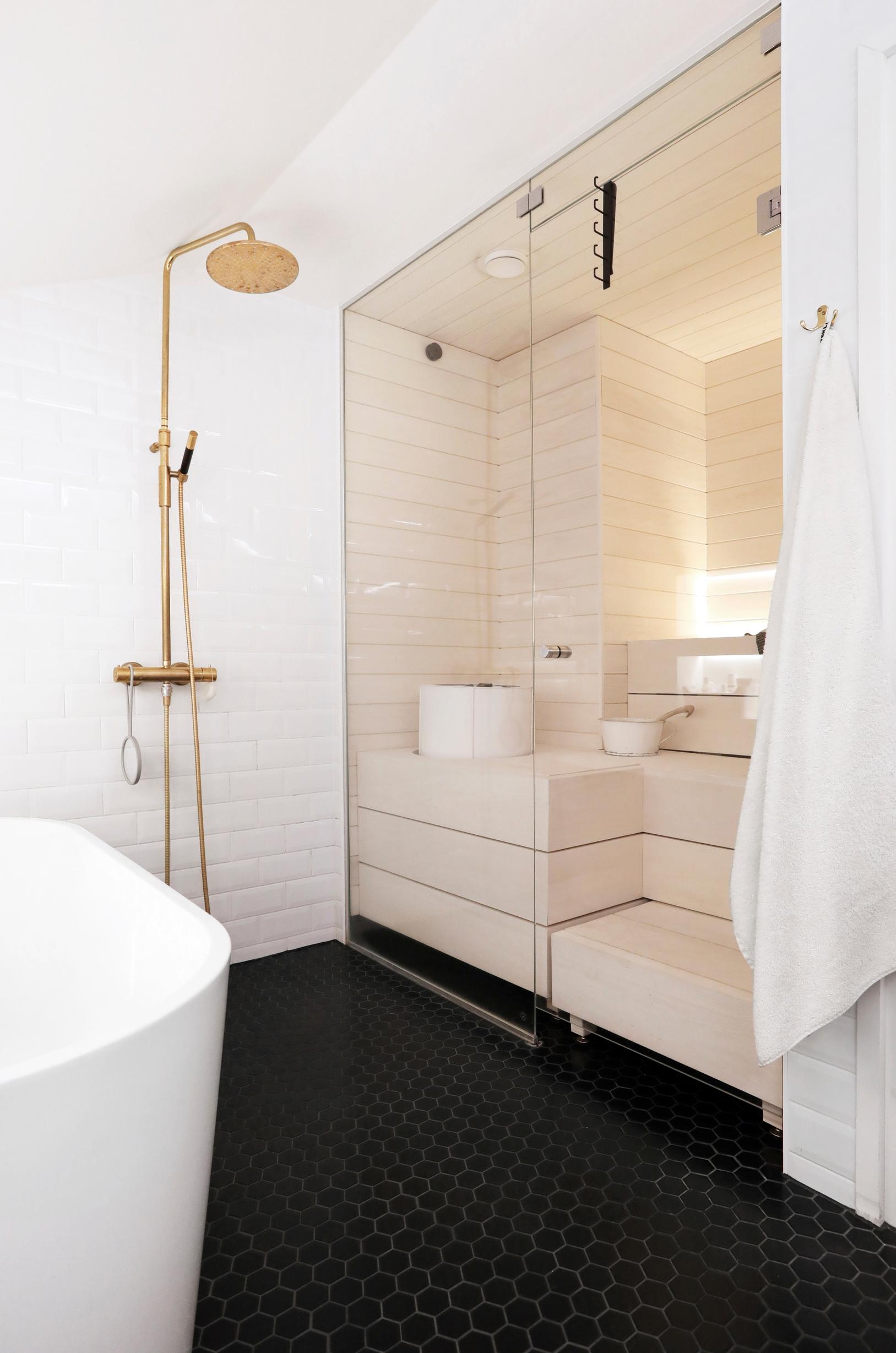 A bright, glass-walled sauna opens up the bathroom