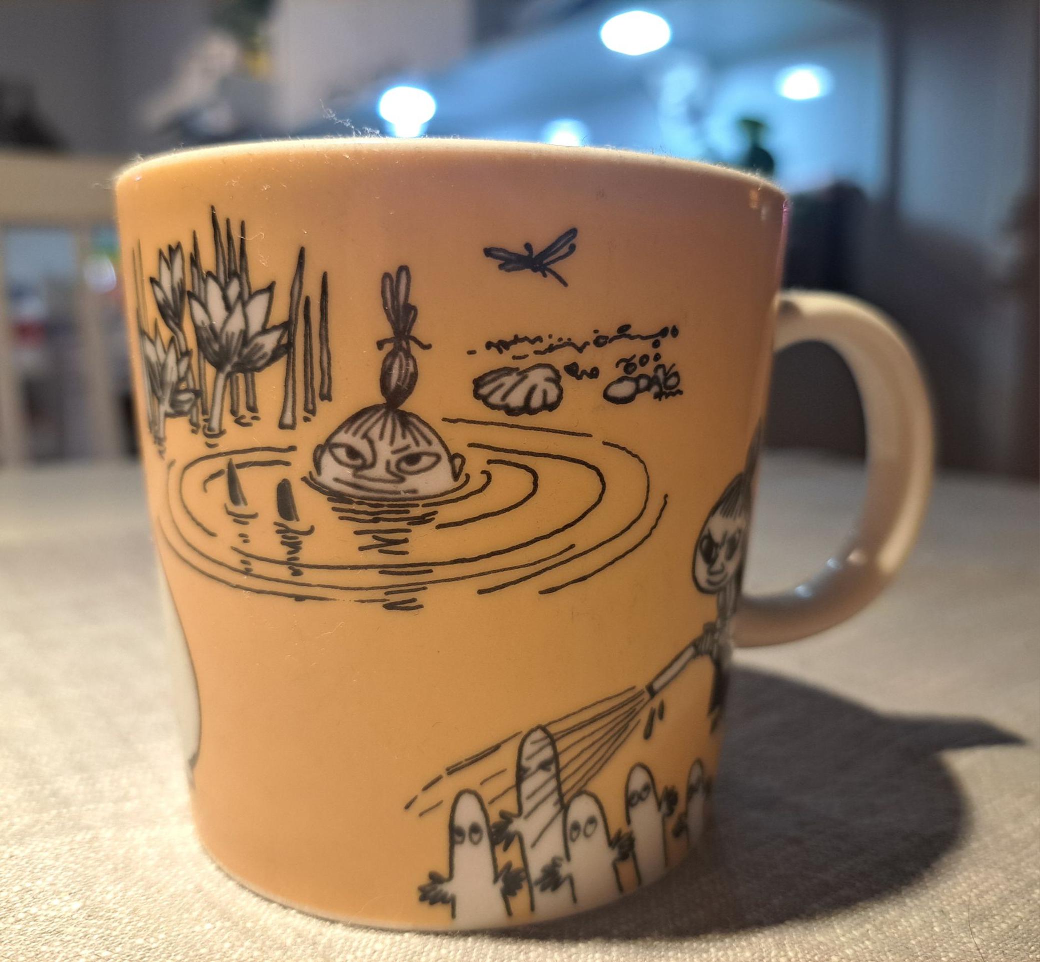 An orange Little My Moomin mug