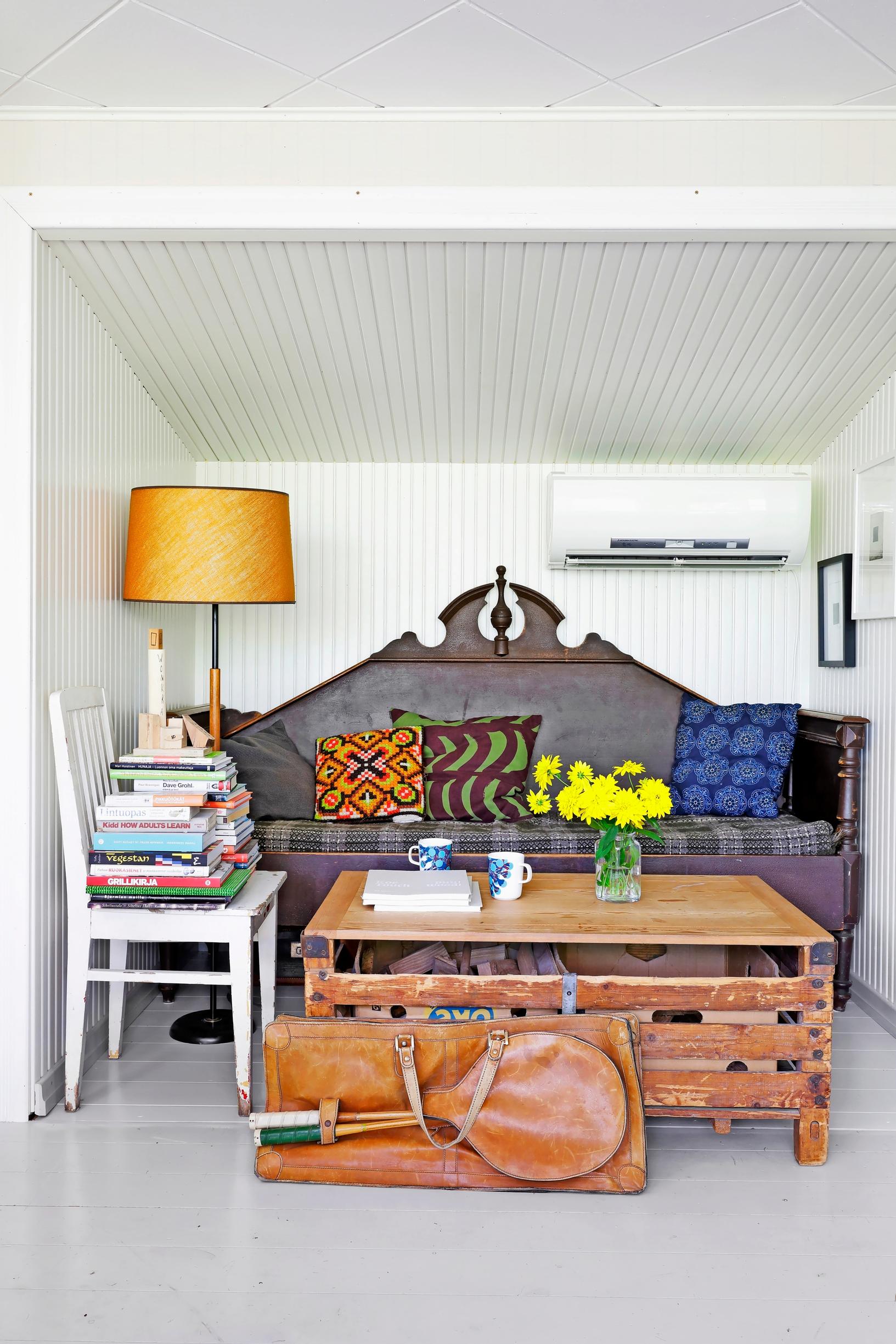 An old wooden crate as a coffee table, with a wooden sofa in the background.