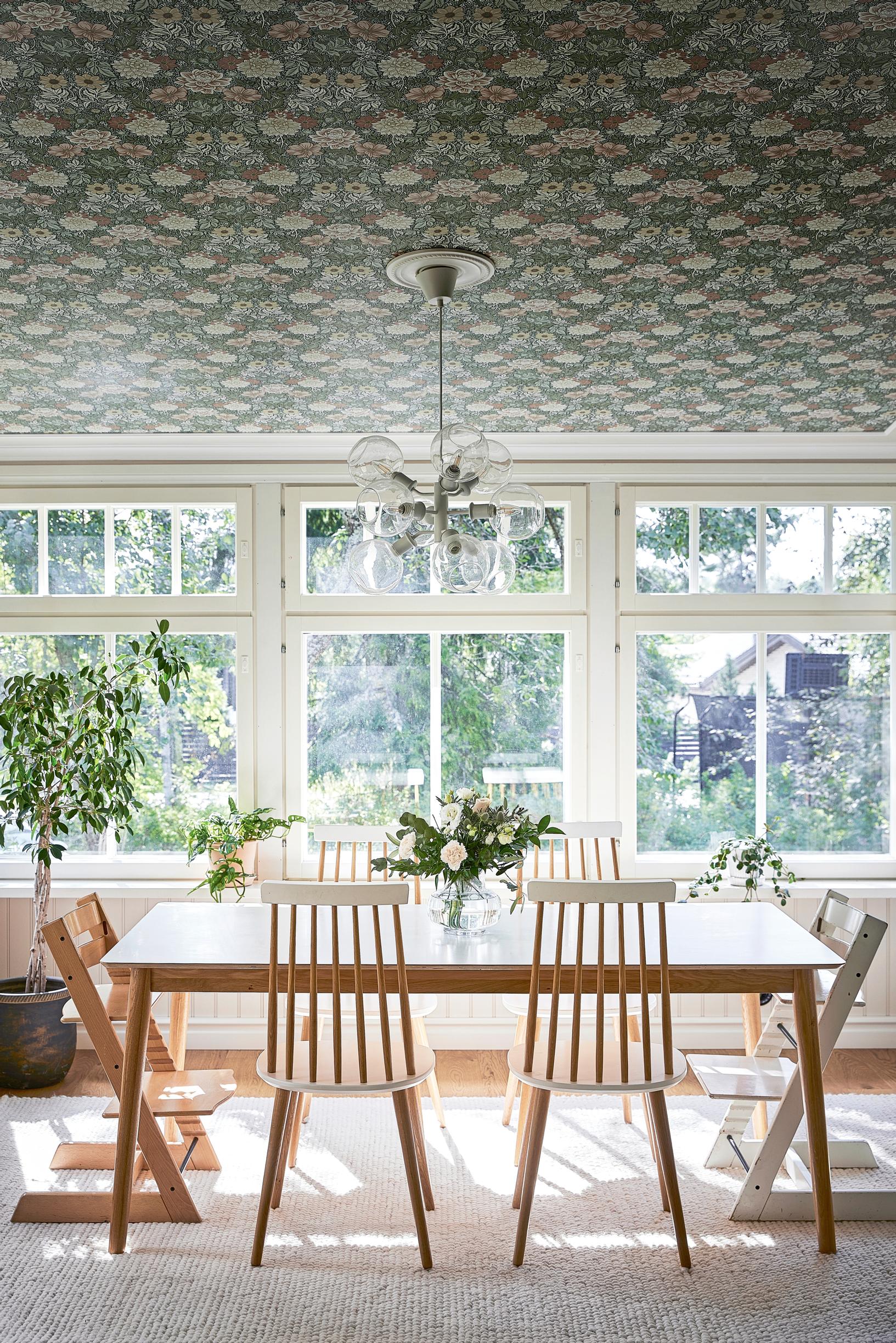 Dining room ceiling wallpapered with a floral pattern