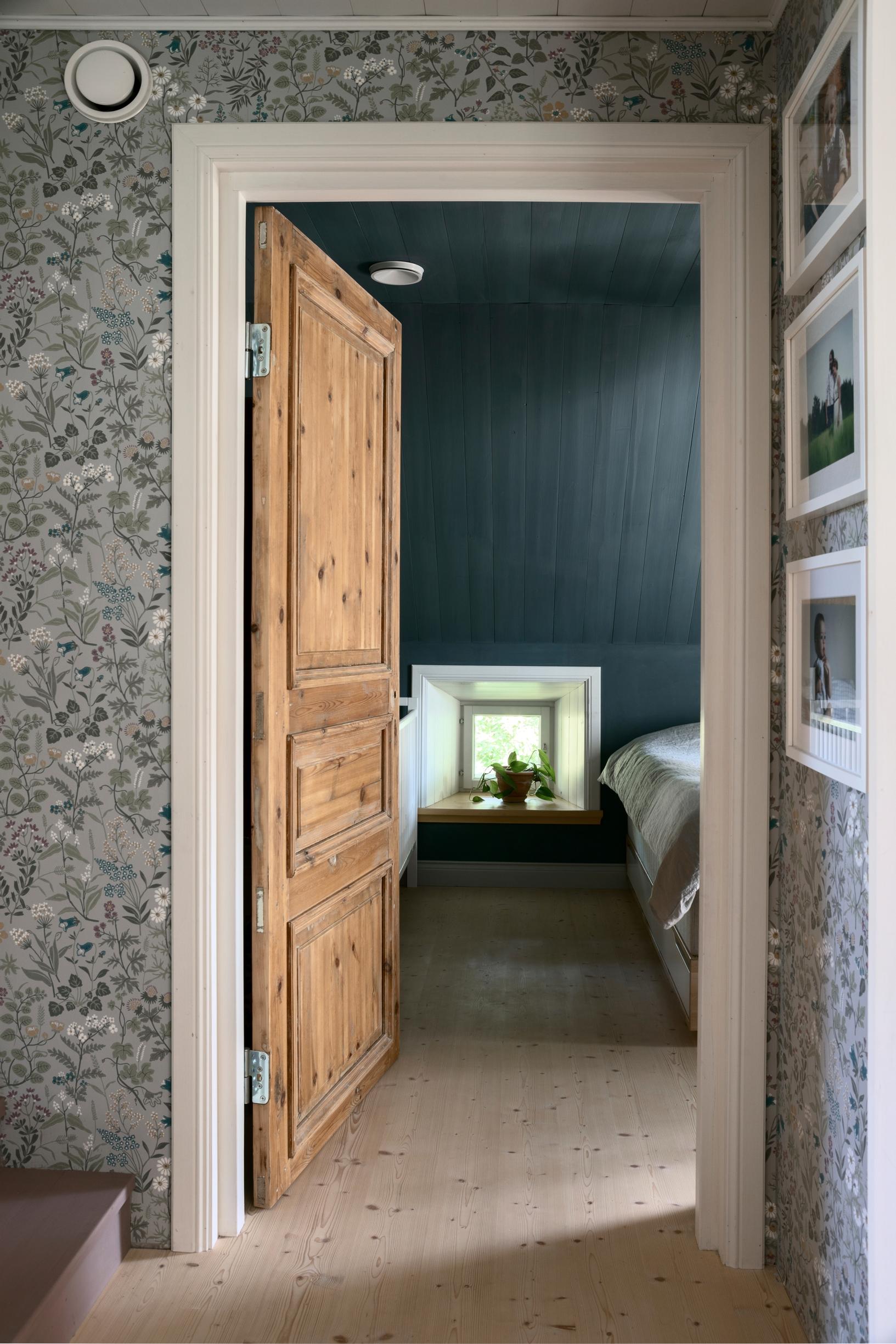 Floral wallpaper and an open door leading to the bedroom