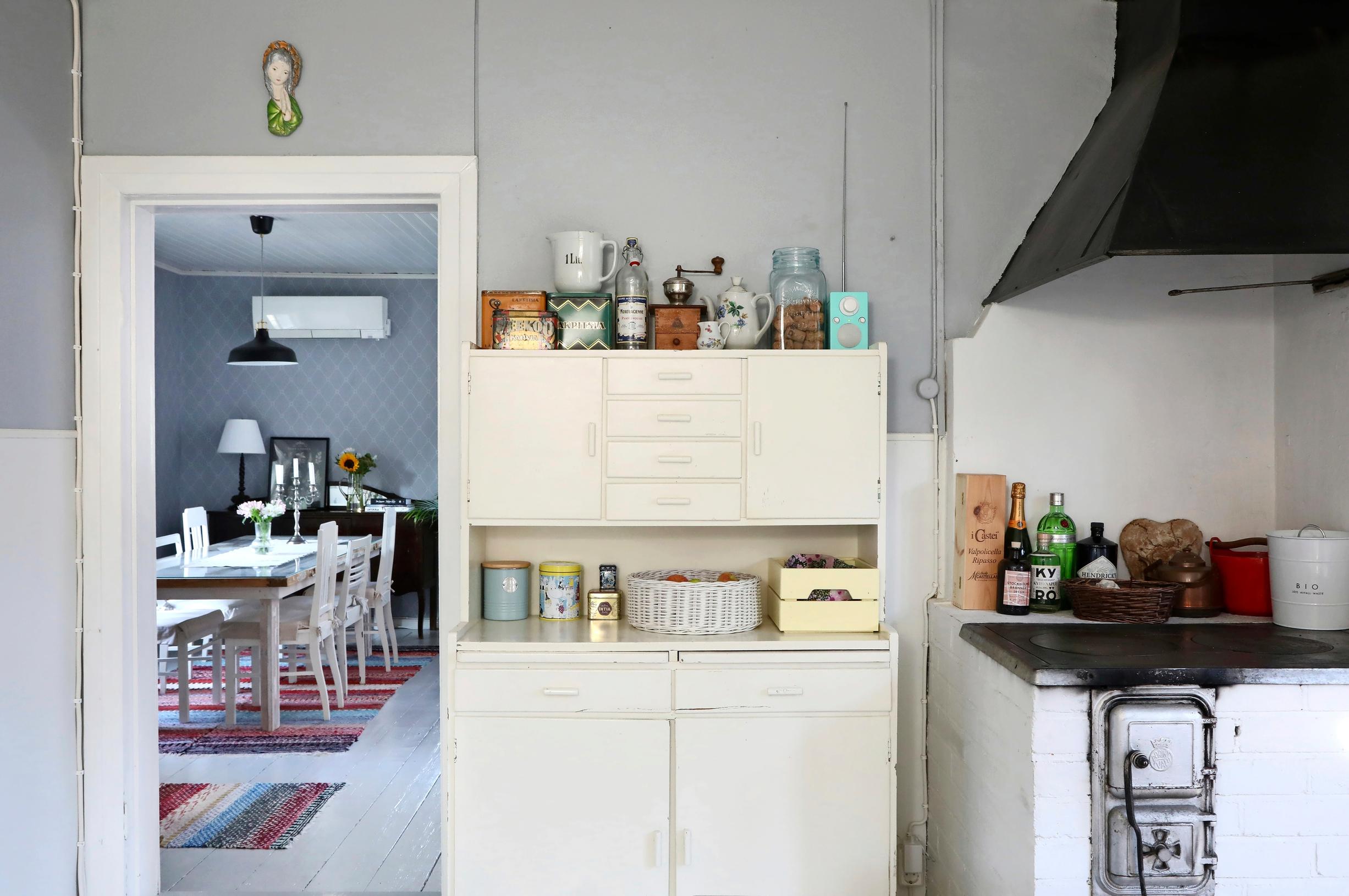 Old kitchen cabinet, wood stove, and a view into the living room