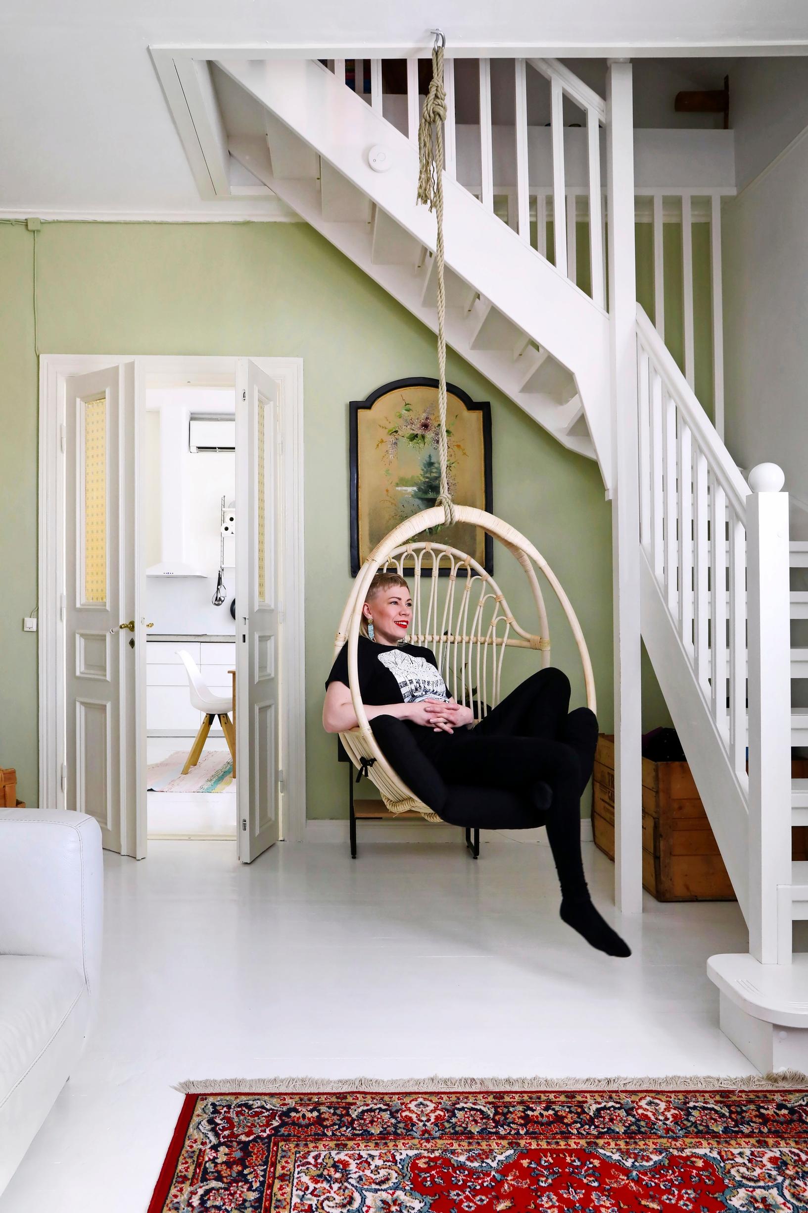 Under the stairs to the attic there's a hanging chair.