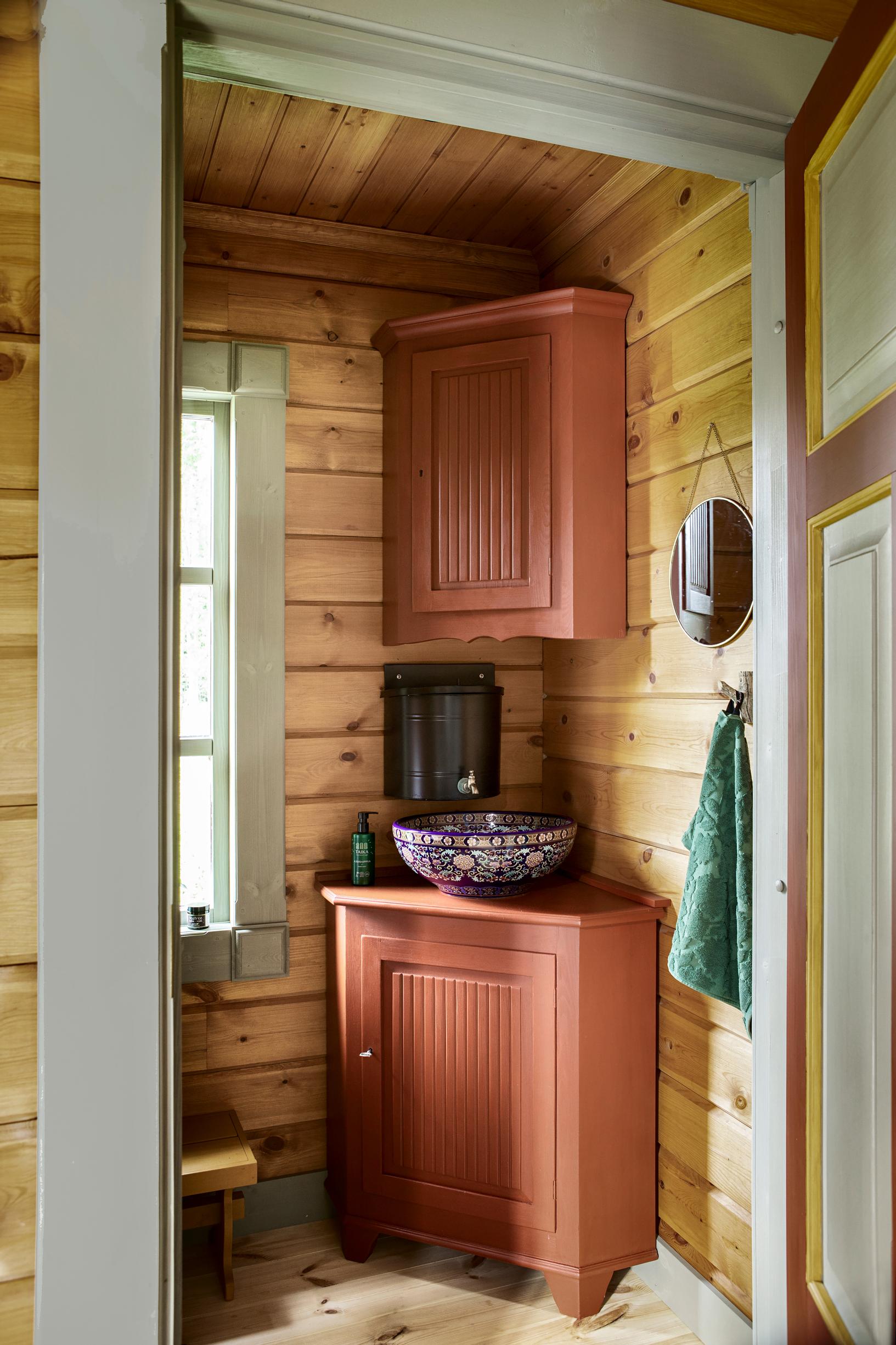 The bathroom sink sits on a repurposed corner cabinet