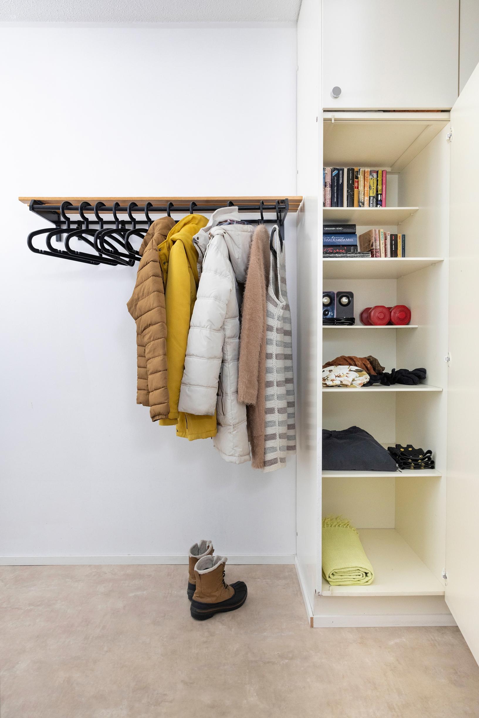 a half-empty coat rack and a cabinet with a few items