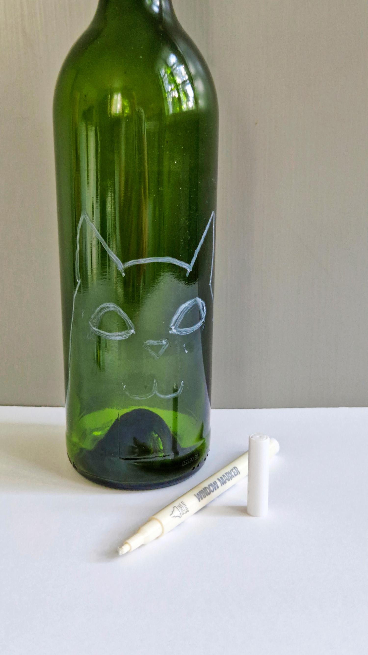 A cat figure drawn on the bottle before painting.
