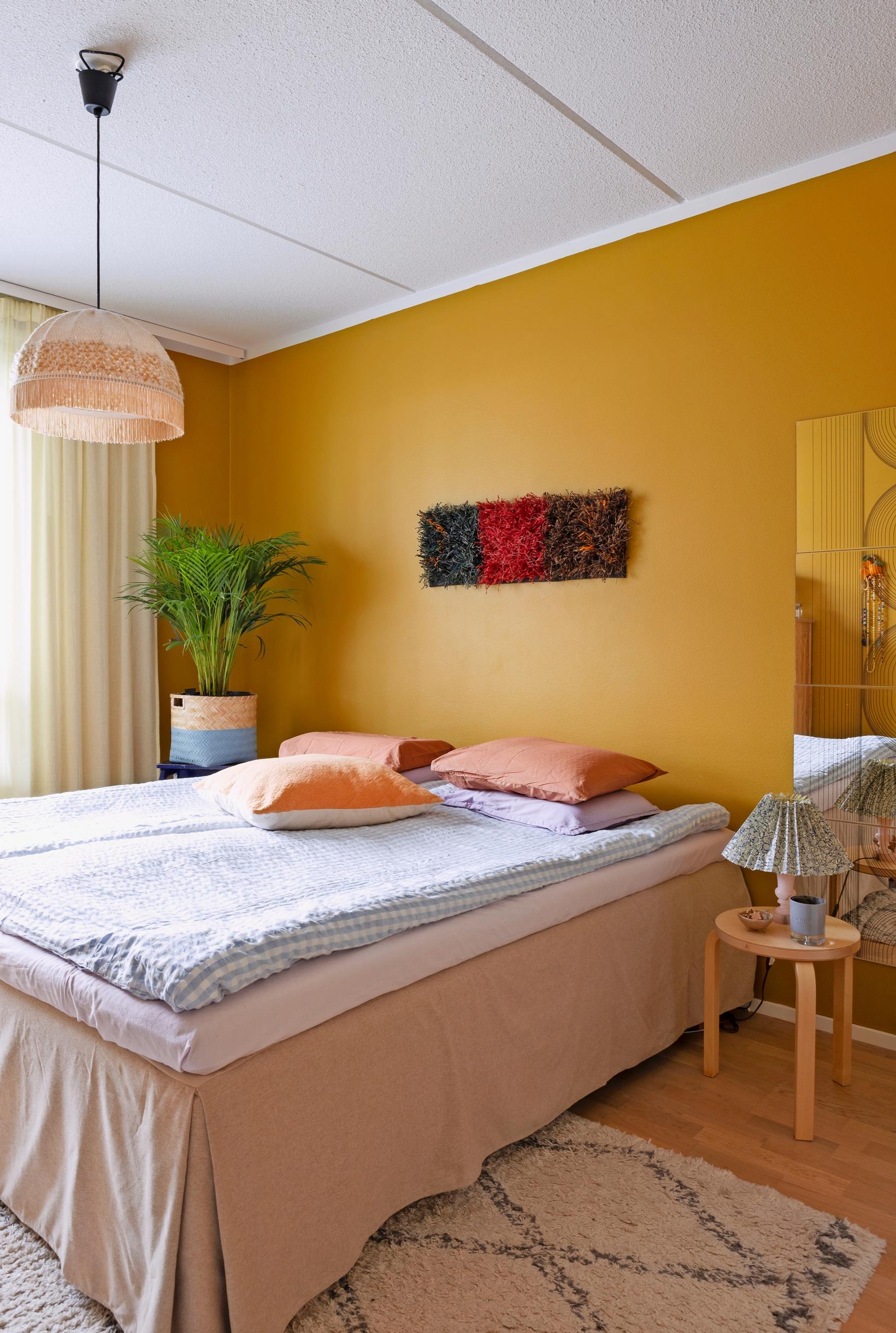 Photo of the bedroom with warm yellow walls.