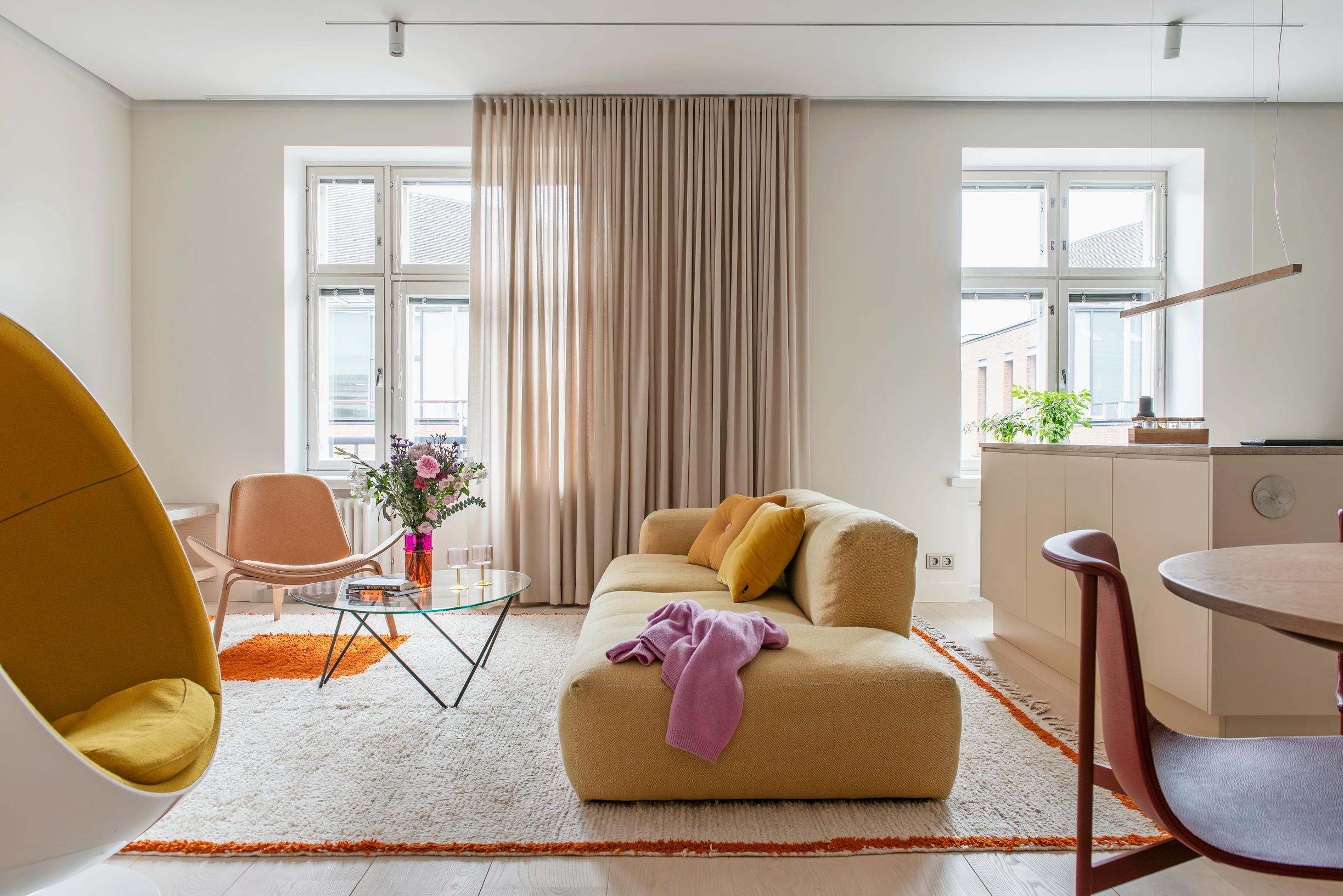 The living room is spacious and serene, featuring a Ball Chair and a plush yellow sofa