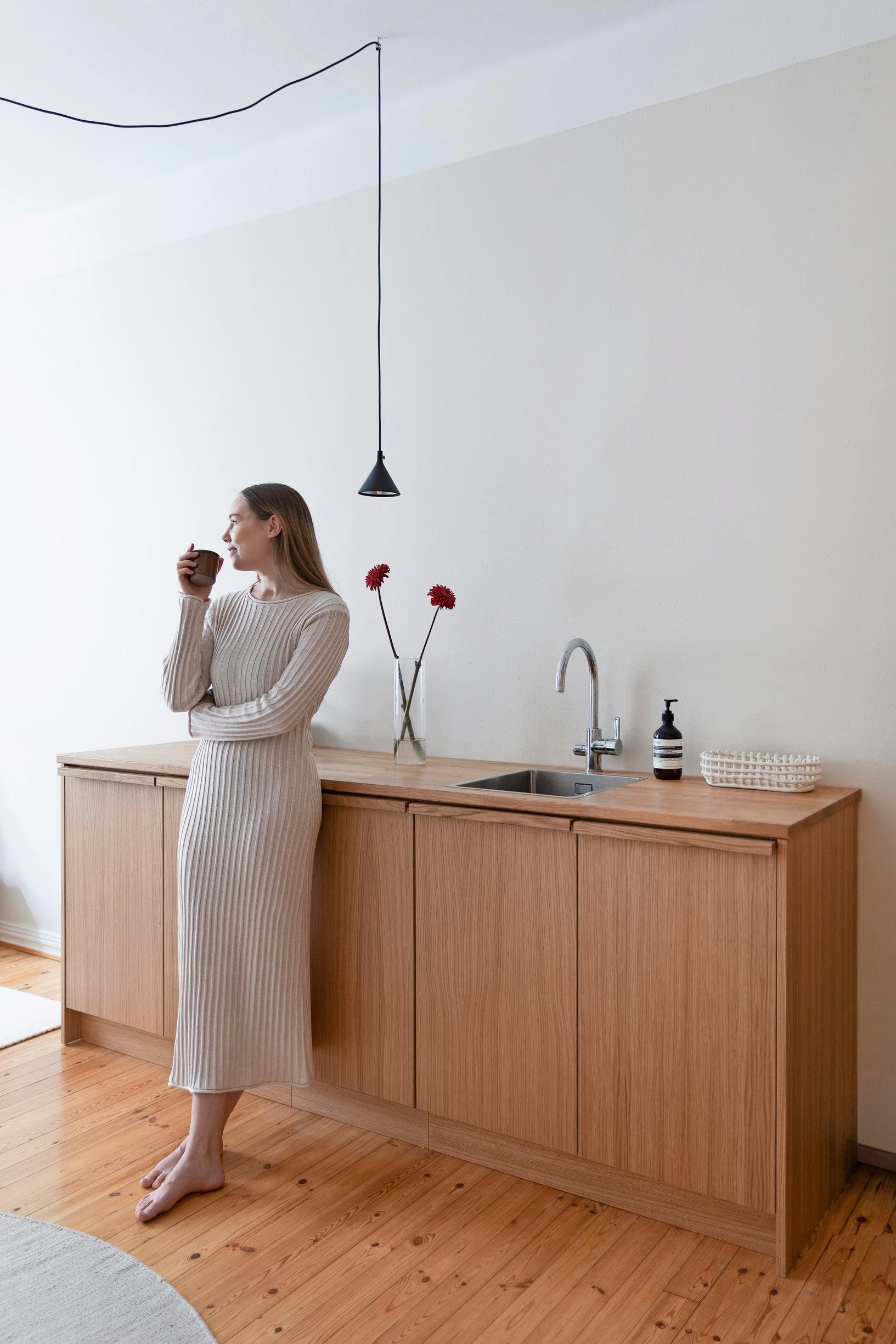 Sara in her wood-toned custom kitchen
