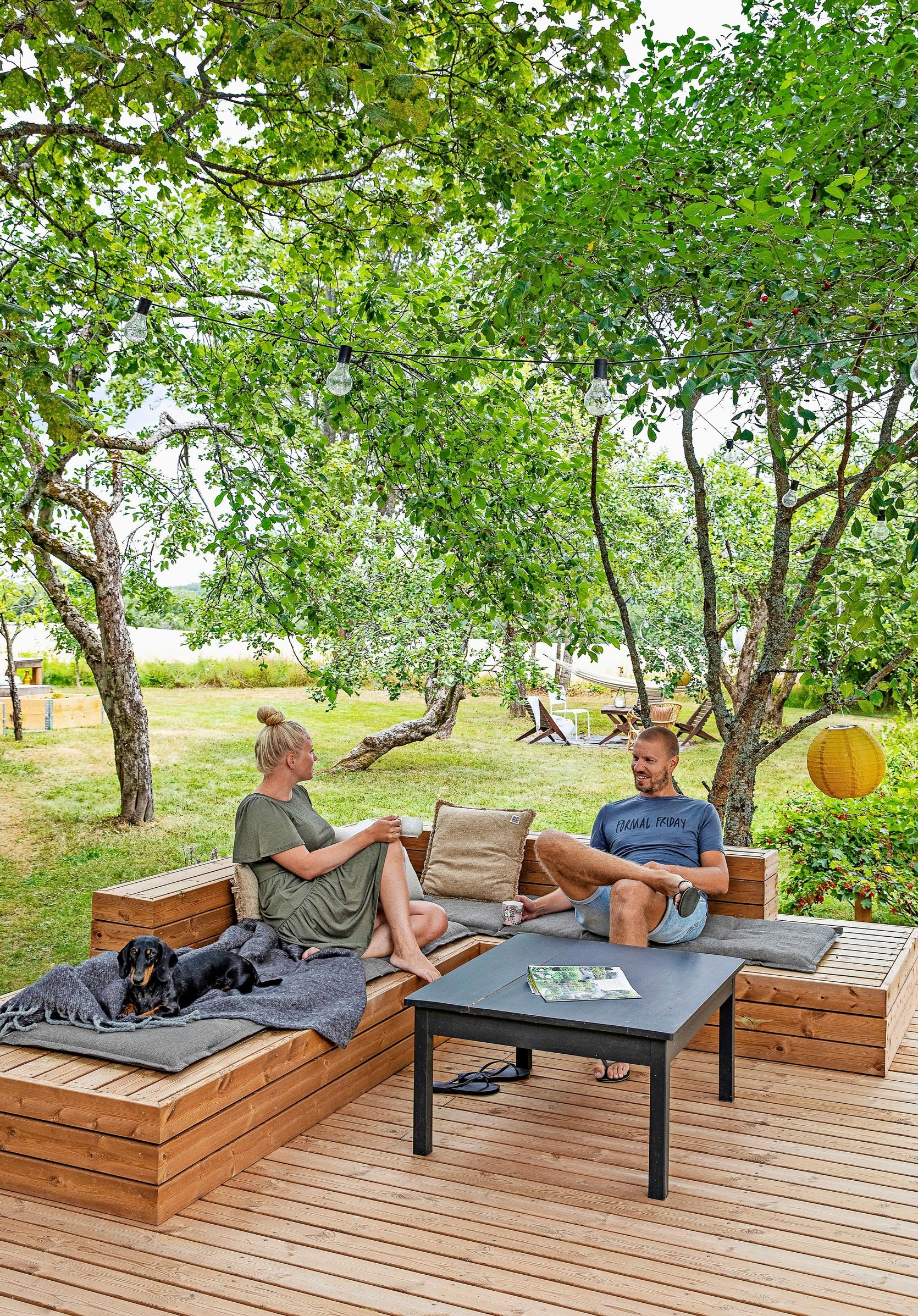 In the shade of old apple trees, a deck and sofa chest with a backrest