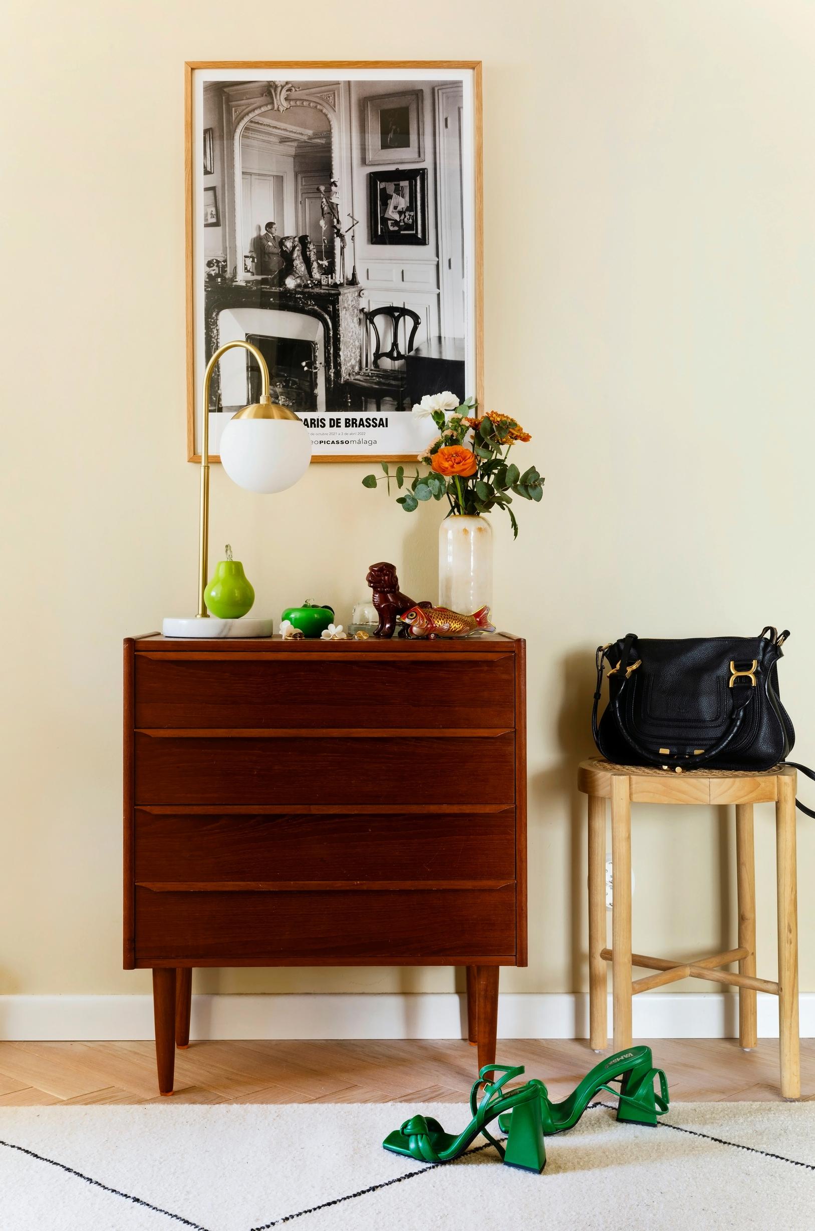A teak chest of drawers in the entryway.