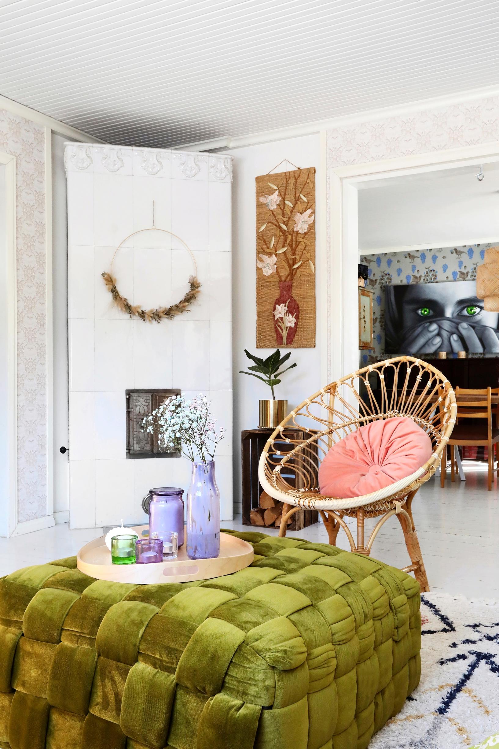 A moss-green ottoman and a tiled stove.
