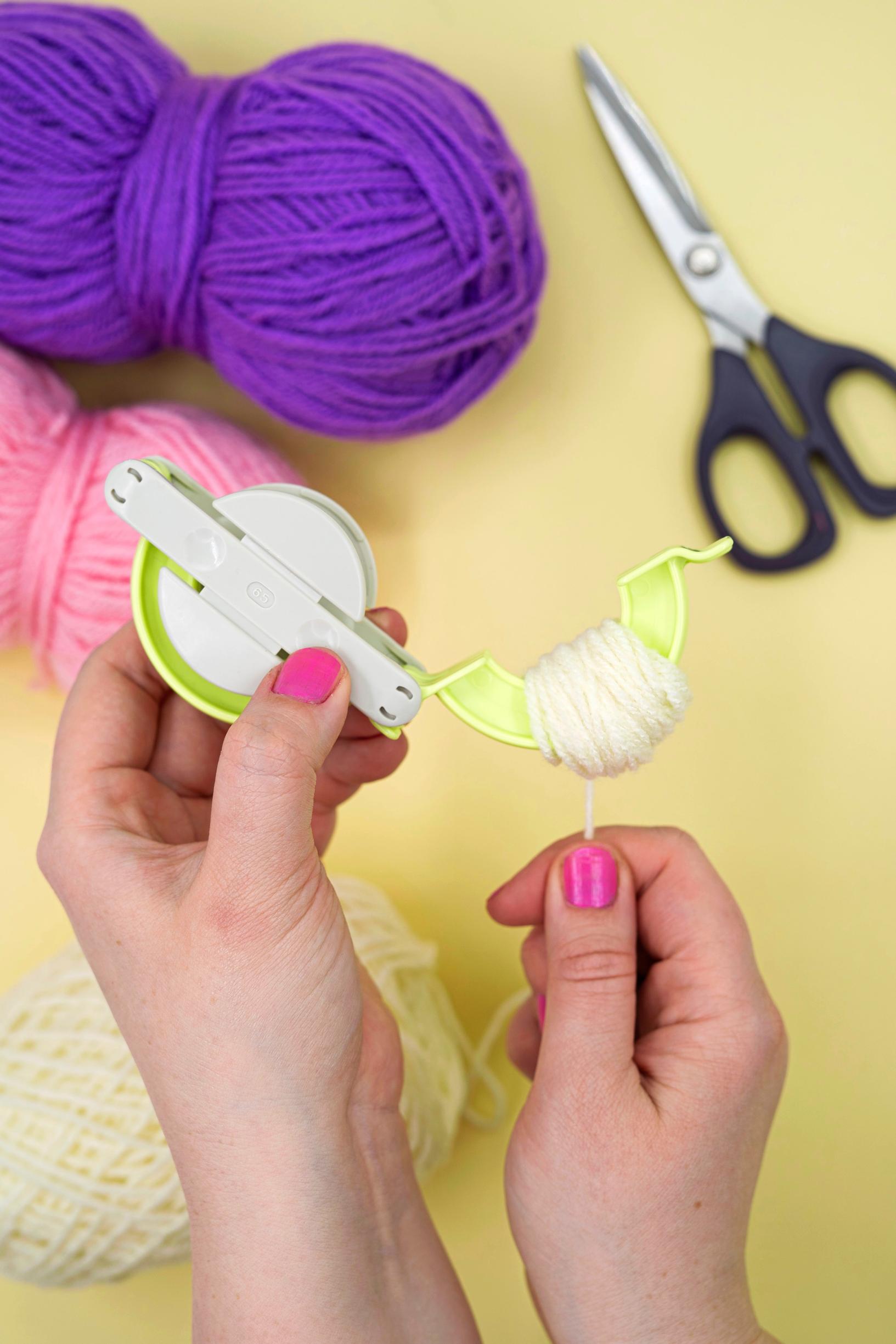 filling the pompom maker with yarn