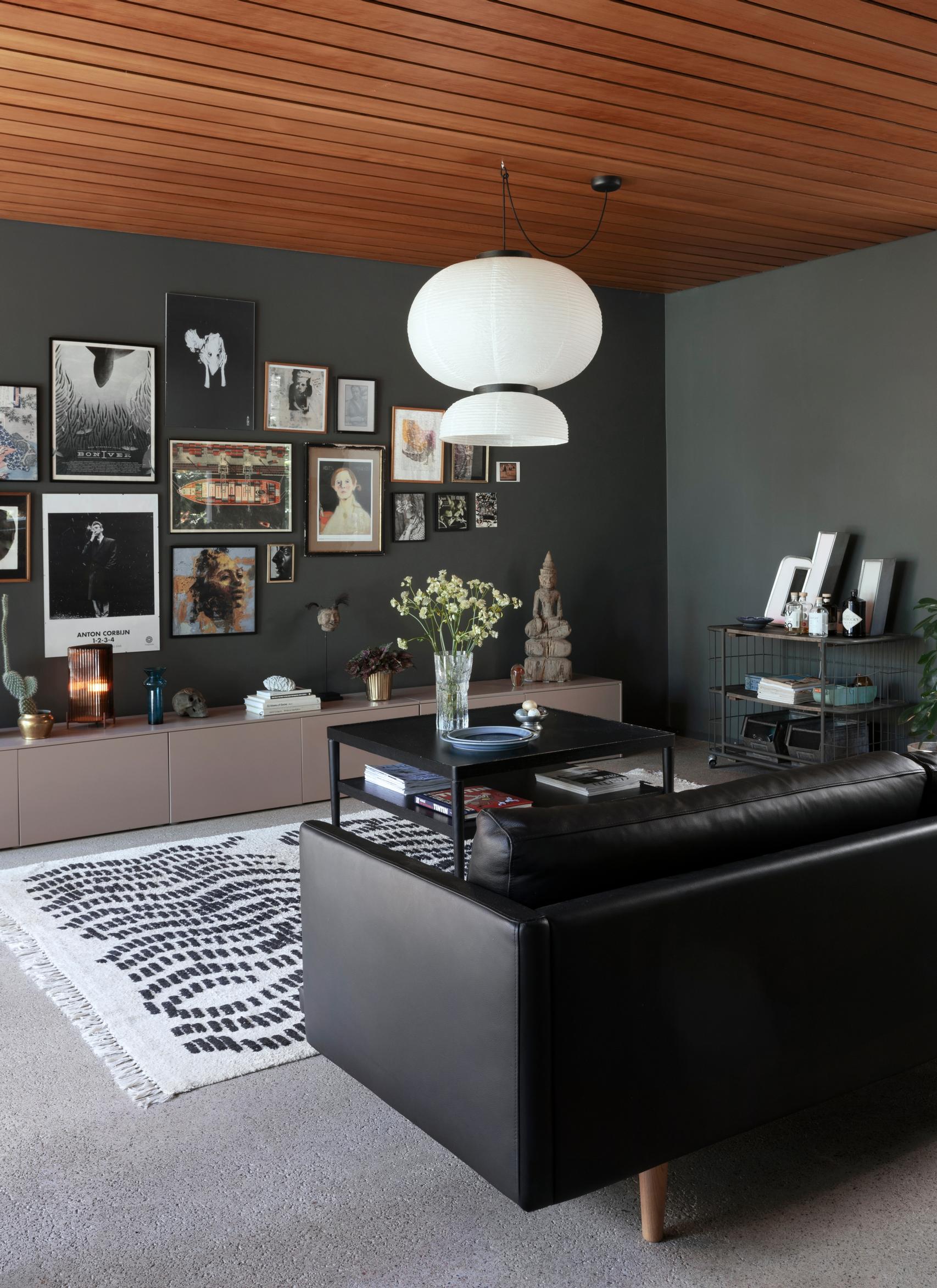 A ’60s-style ceiling panel and black leather sofa