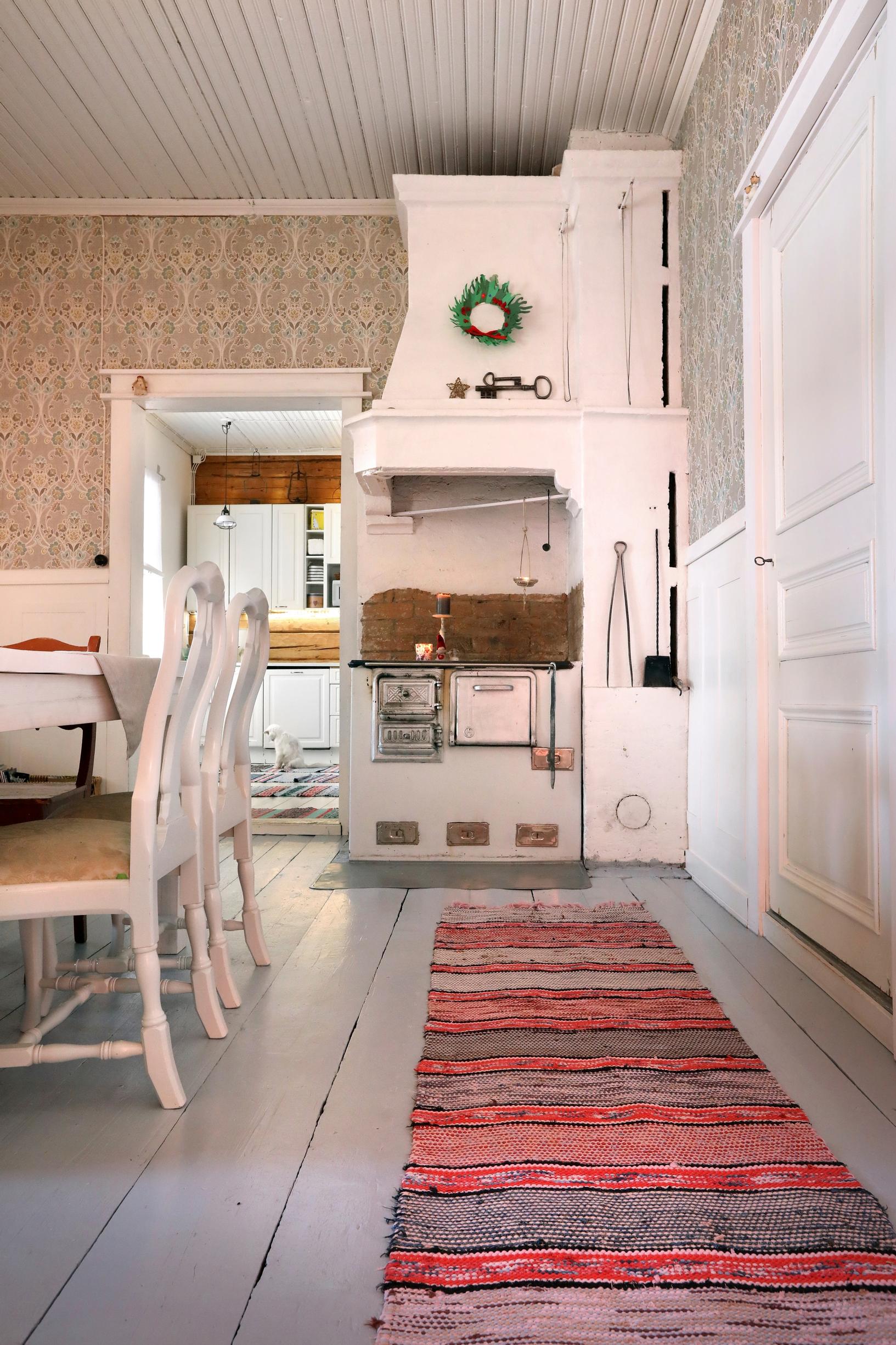 A wood-burning stove and a red rag rug
