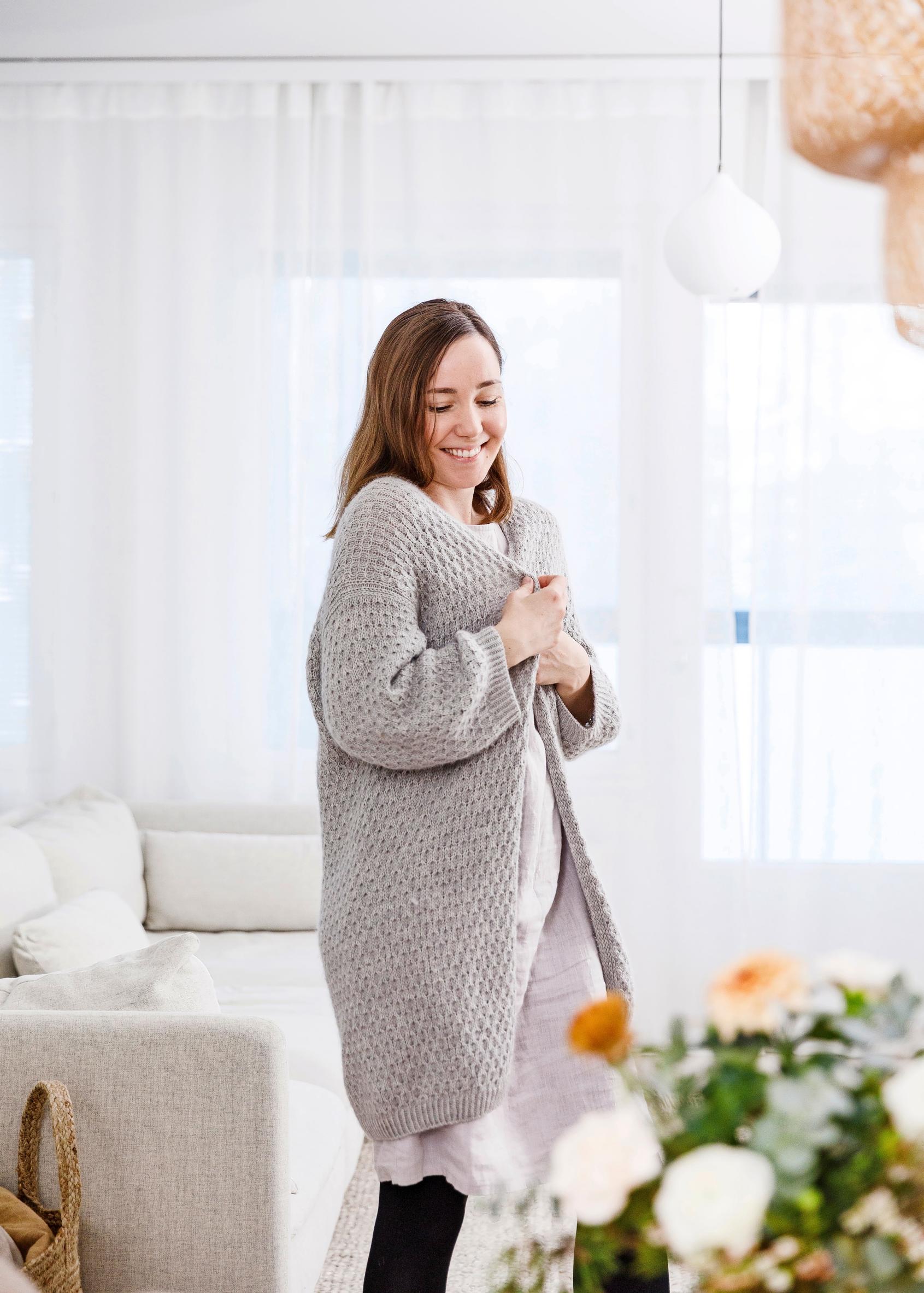 Anna wearing a long gray cardigan.