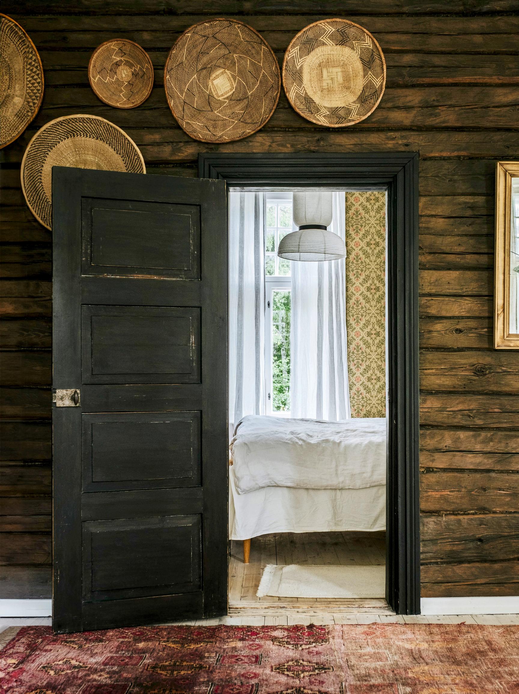 A view from the living room into the bedroom. The log walls have been treated to a dark finish.