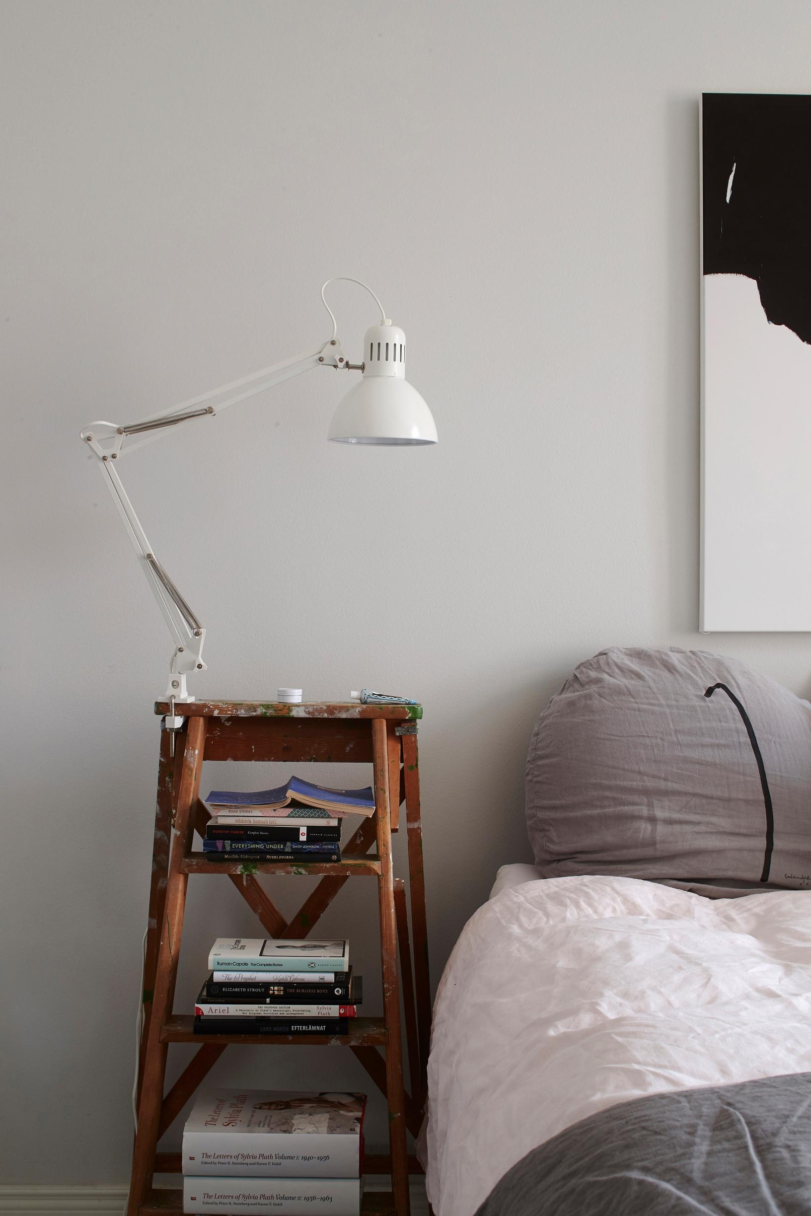 Antique painter’s ladder repurposed as a nightstand.
