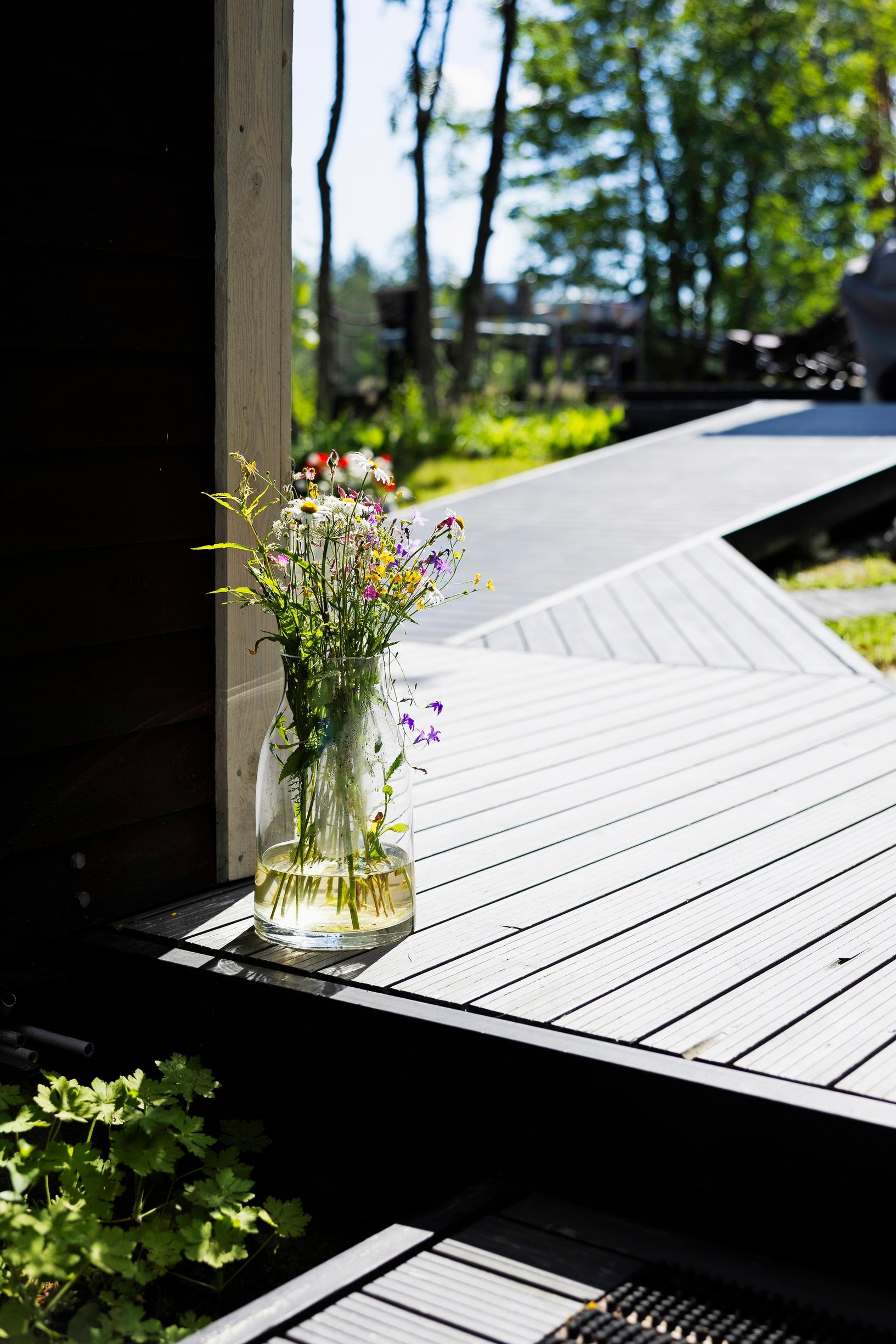 wooden decks, with a bouquet of flowers in a glass vase in the foreground