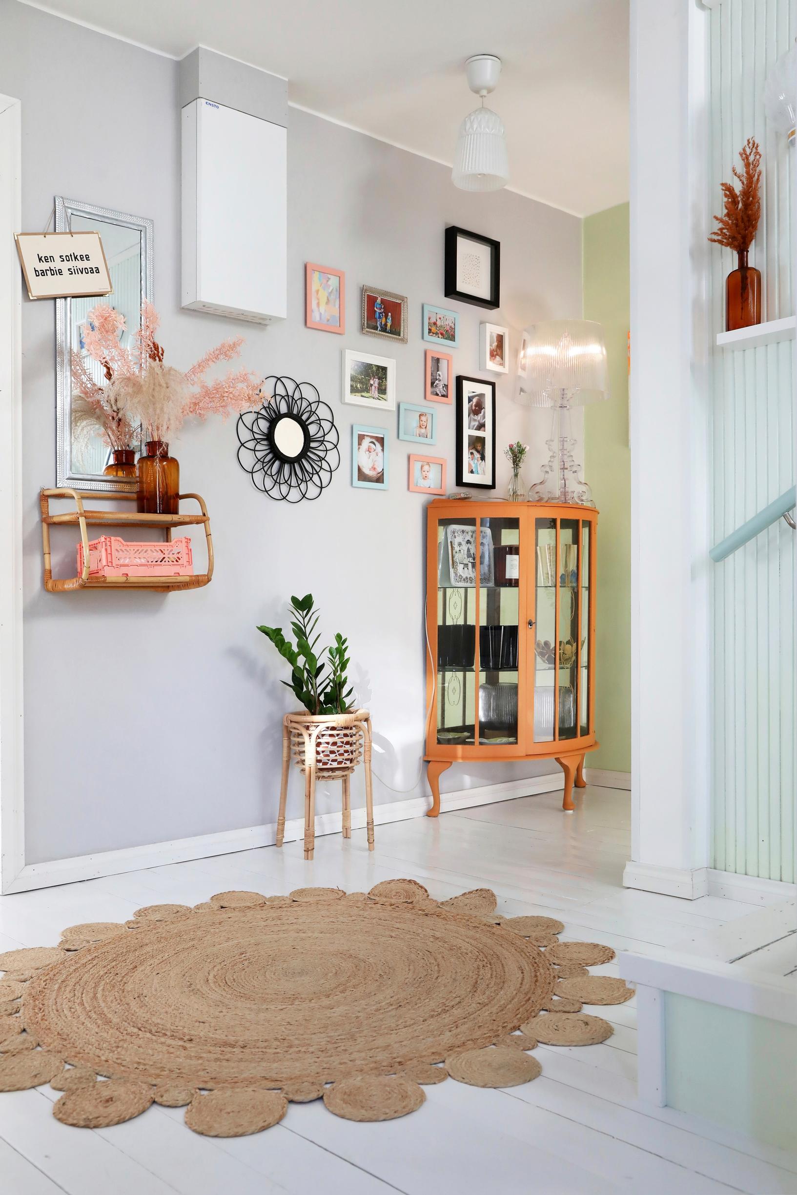 Mushka’s entryway with a gallery wall and an old semicircular glass display cabinet.
