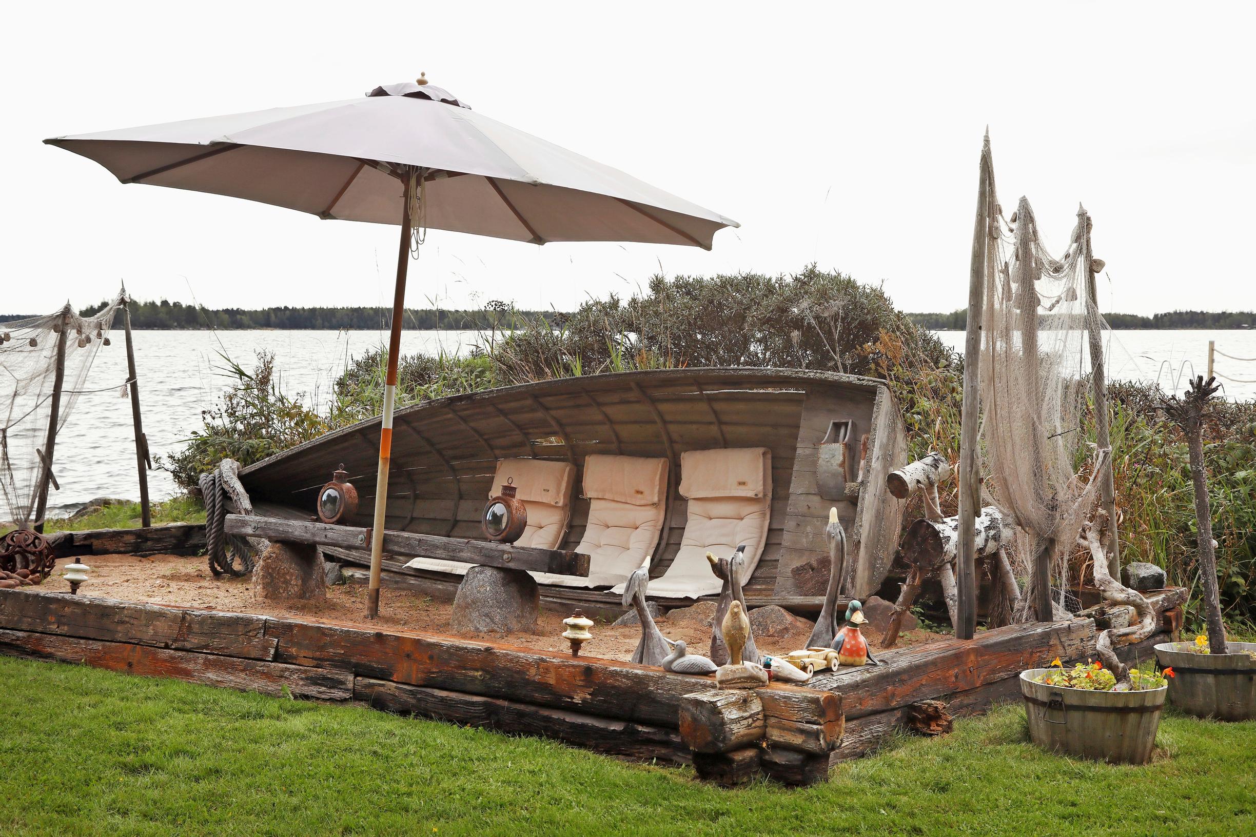 A boat placed on the edge of the sandbox and a seascape.
