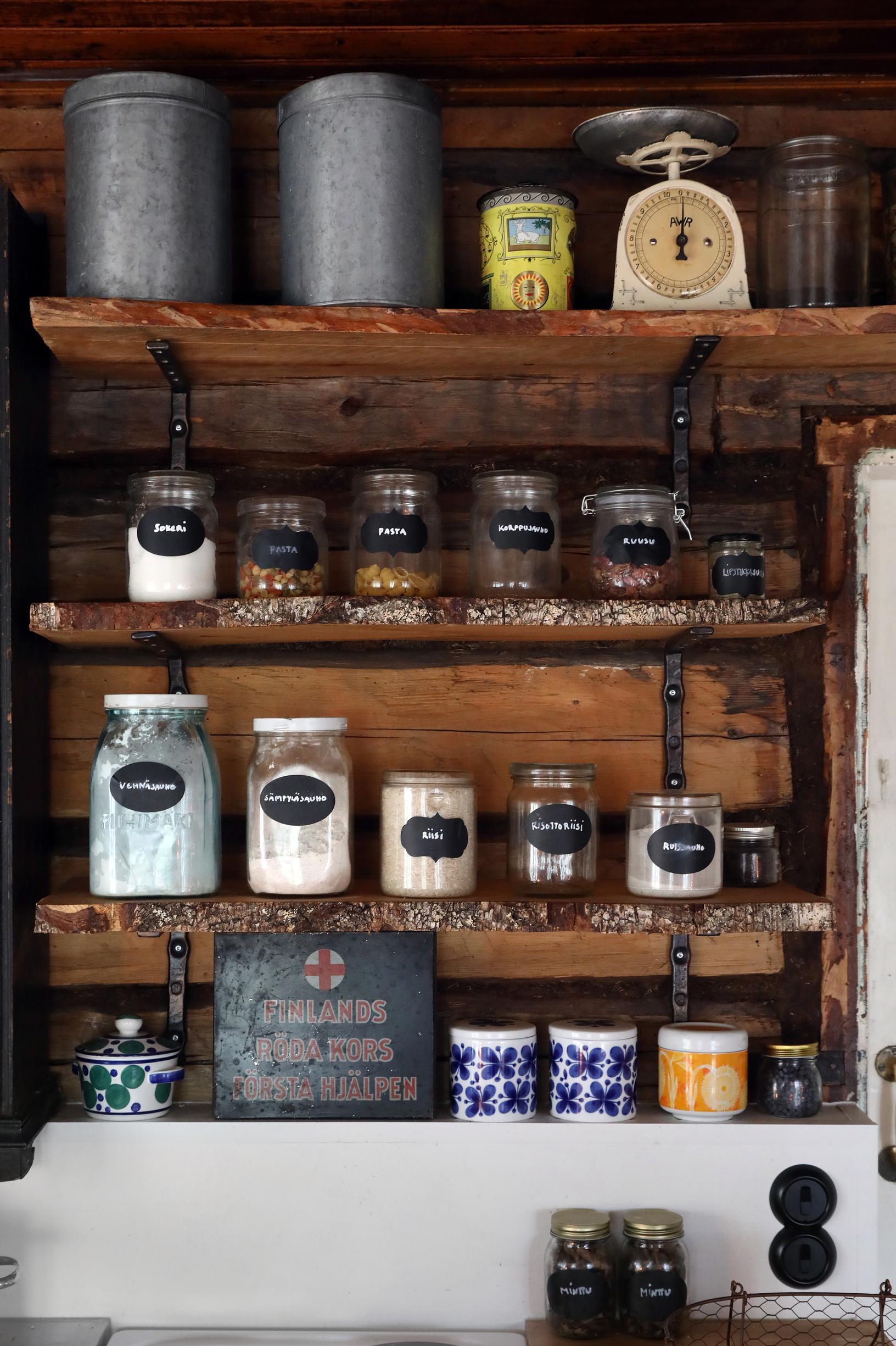 The kitchen shelves of the log house made from old boards.