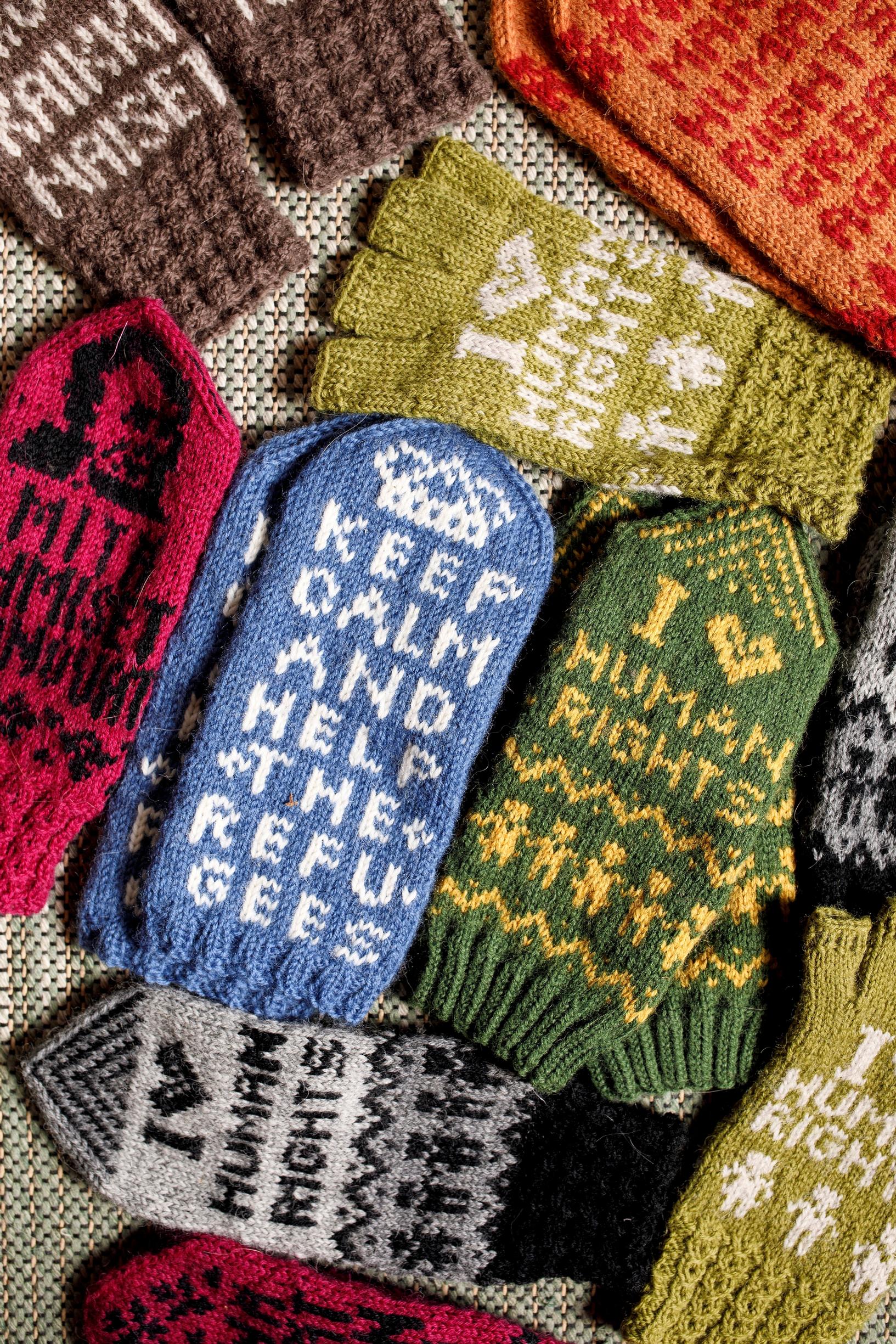 Knitted mittens that read ‘I love human rights’ and ‘Keep calm and help the refugees’