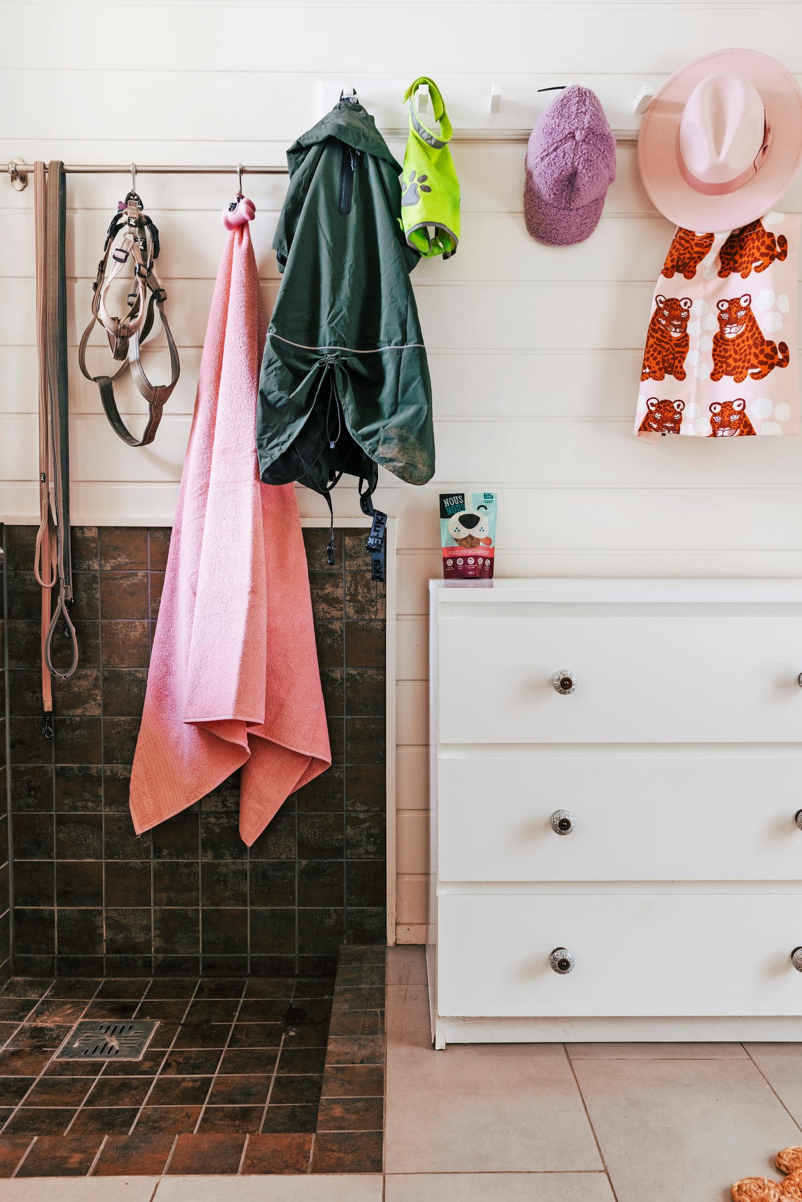 a tiled shower area with a dresser next to it