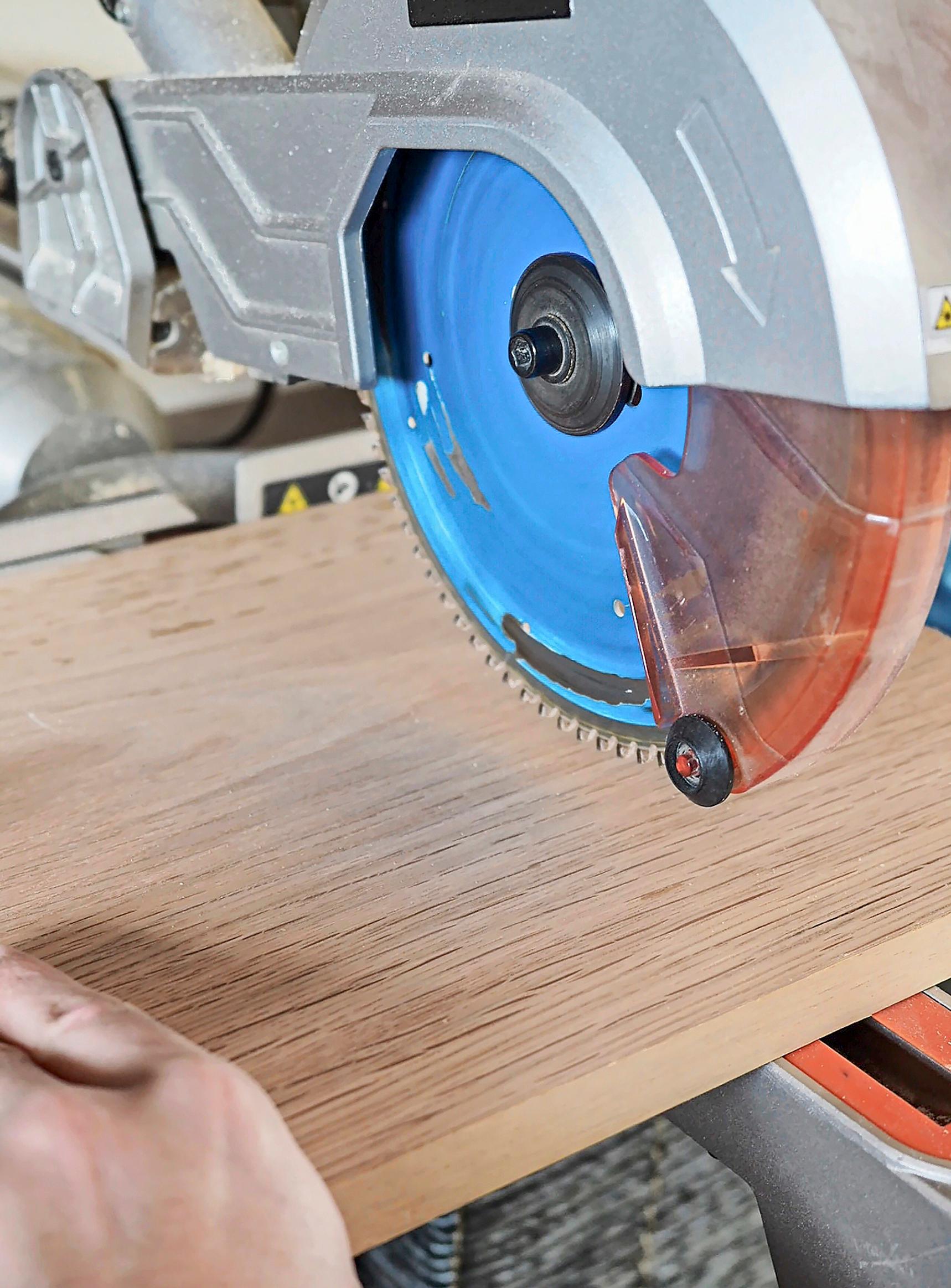 Sawing a wooden board with a crosscut and miter saw.