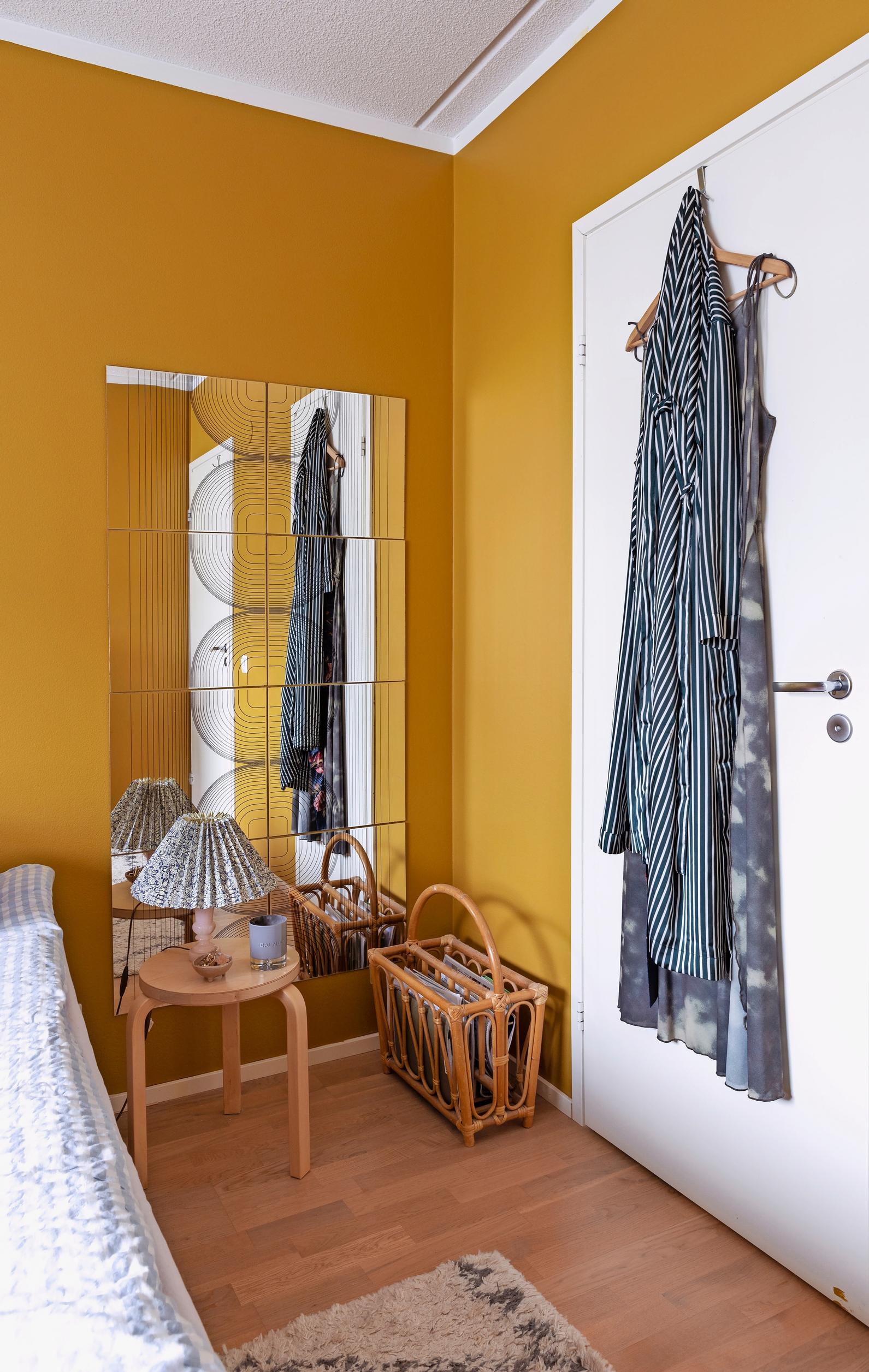 Photo of a corner of the yellow bedroom with a modular mirror.