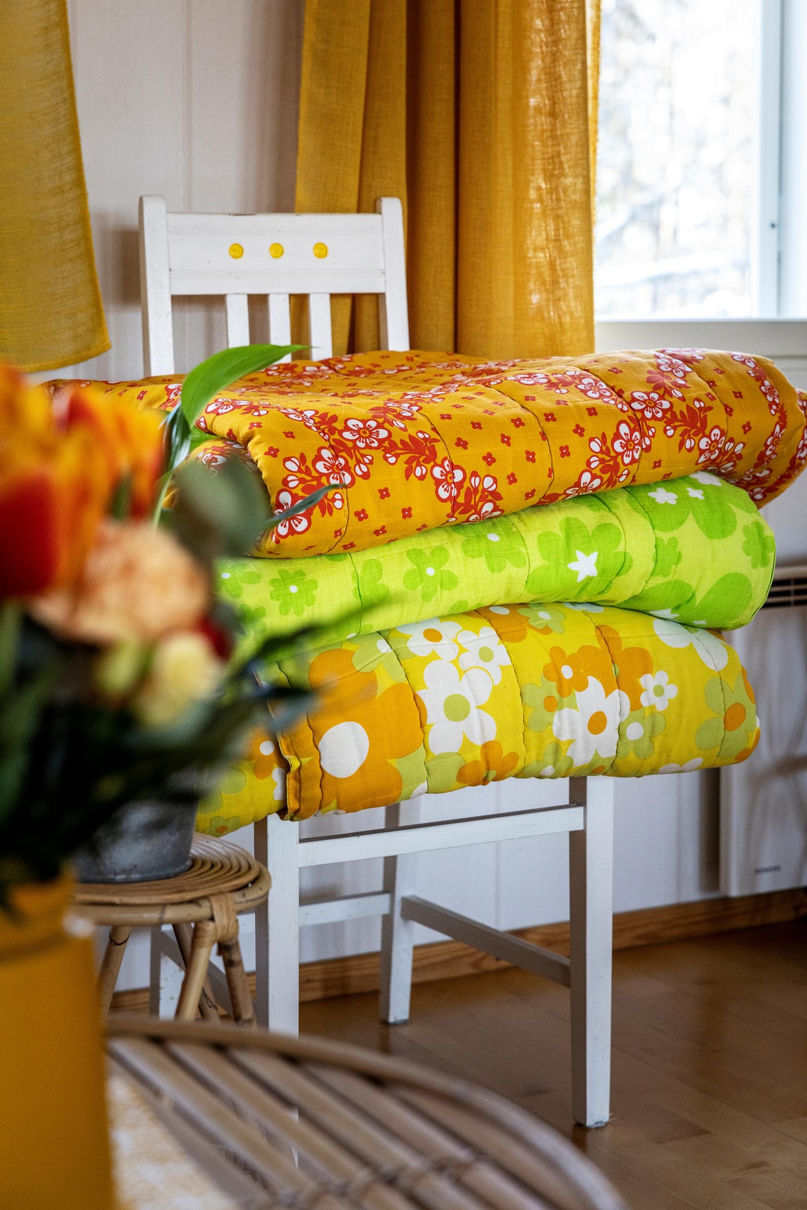 A chair stacked with vintage quilts.