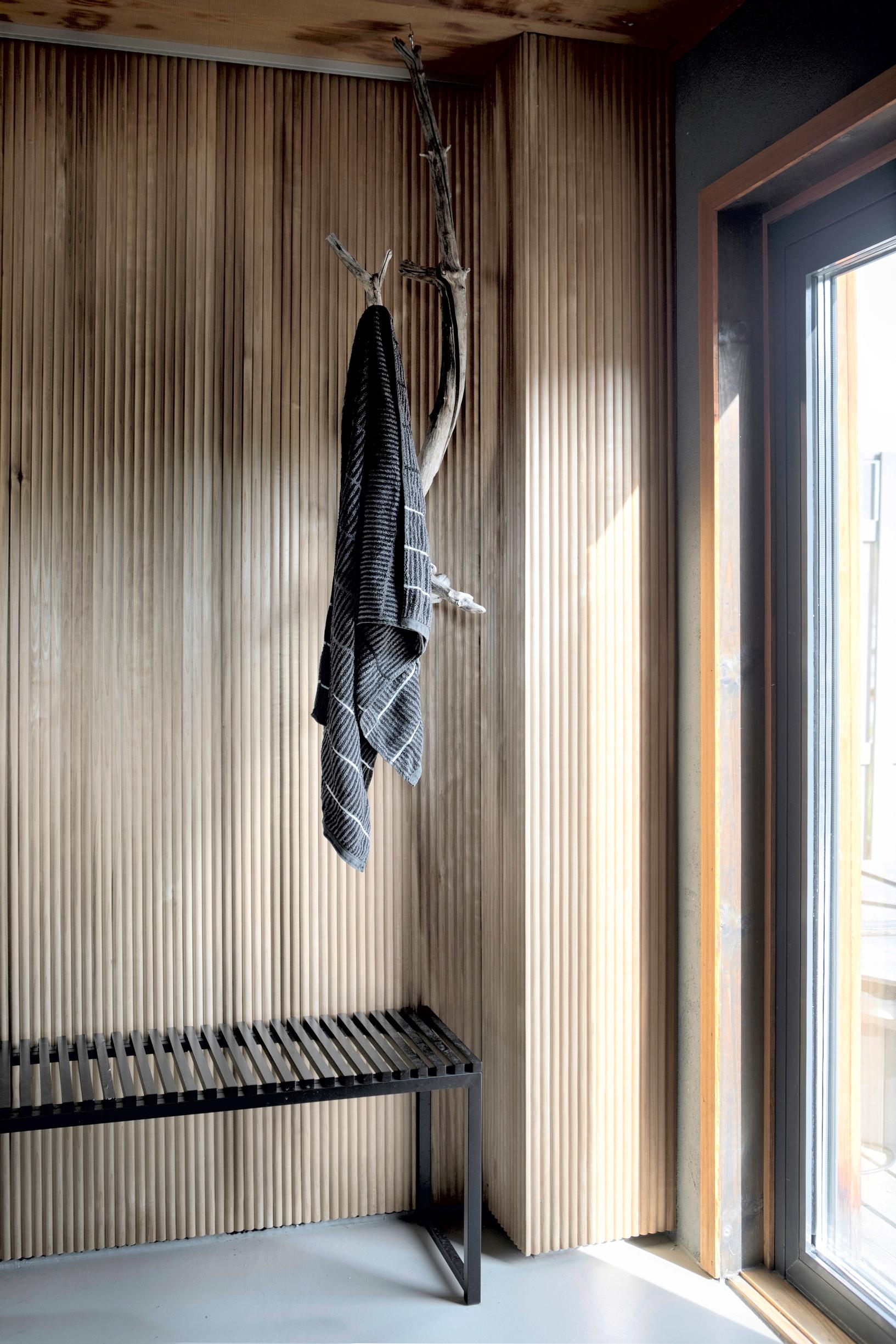 In the sauna’s entryway, the coat rack is made from a tree branch