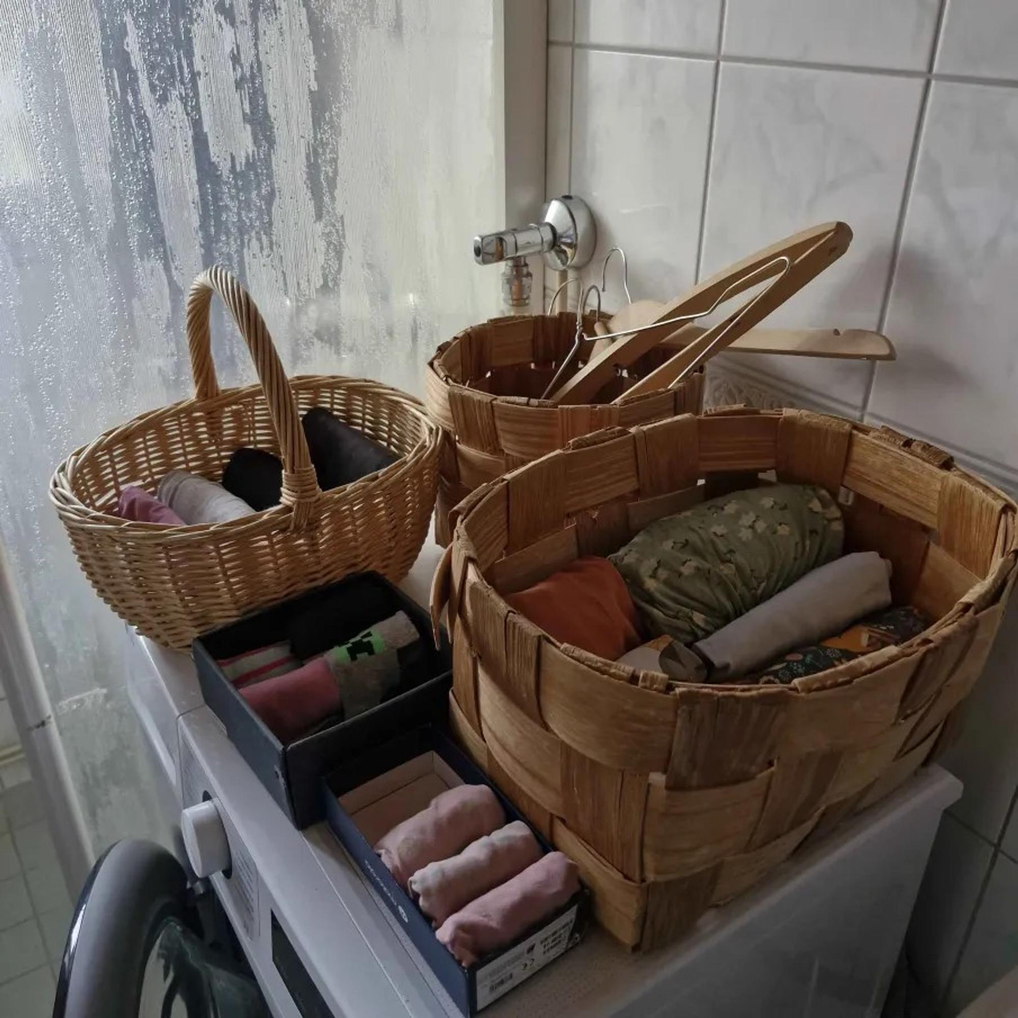 three baskets and two small boxes on top of a washing machine