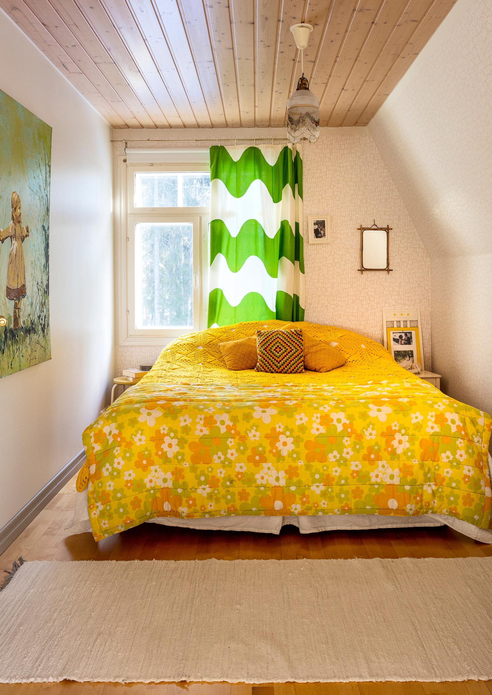Samuli and Elisa’s bedroom with a yellow vintage quilt and a Lokki curtain.