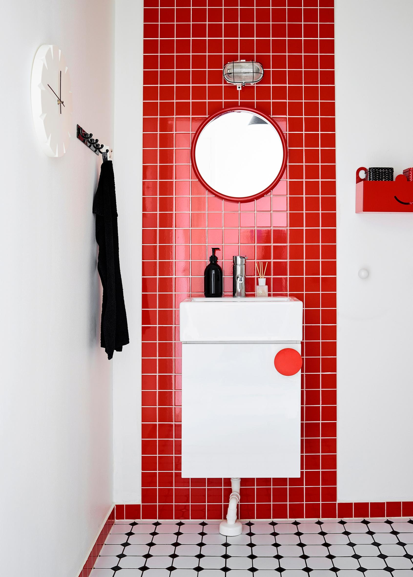 The small bathroom tiled in red and white.