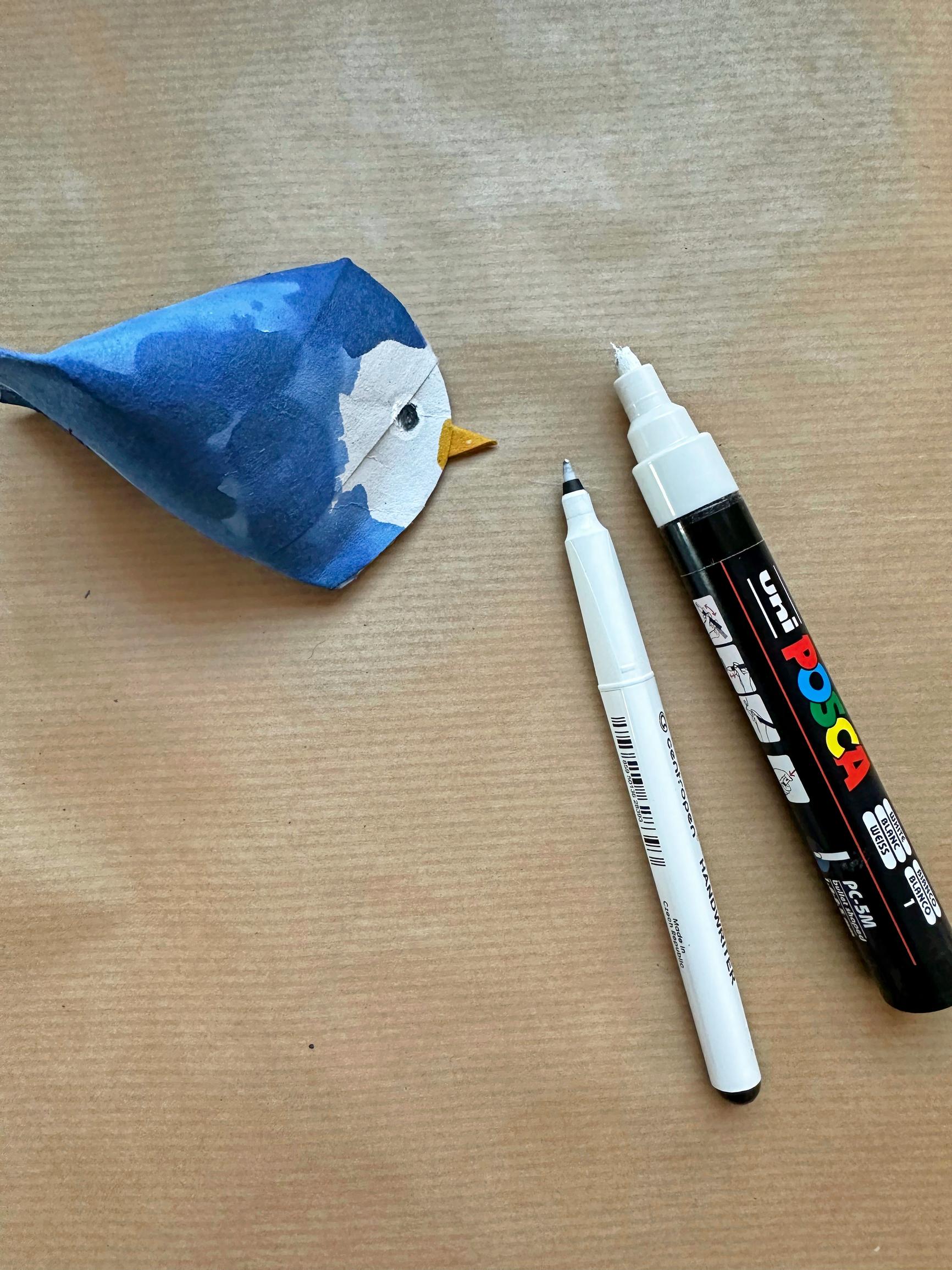 A bird crafted from a toilet paper roll, painted blue