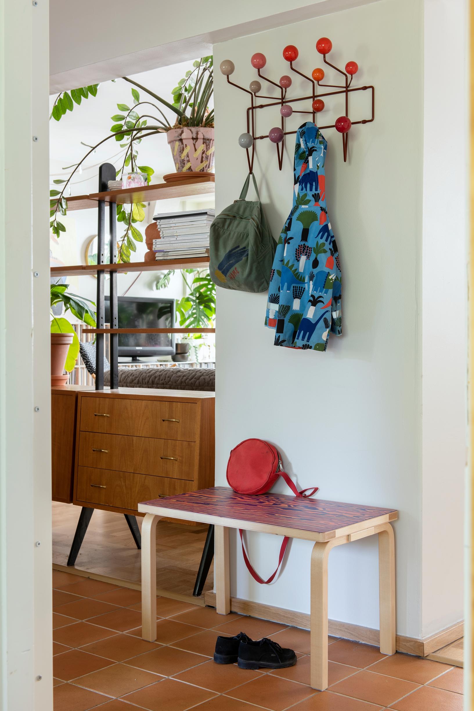 A colorful Vitra wall coat rack and Artek's Aalto ColoRing bench in the entryway