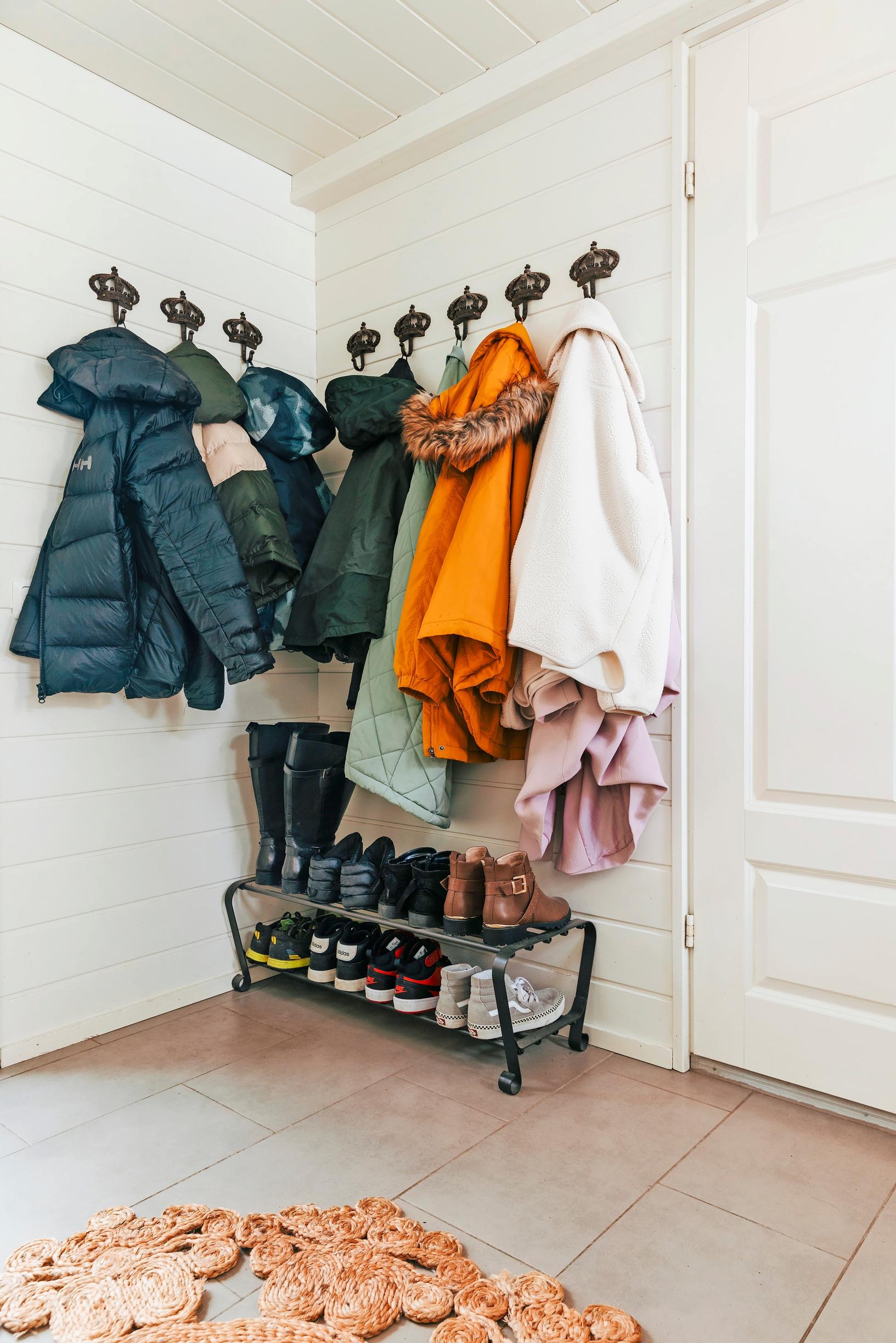 jackets on wall-mounted hooks, shoes lined up on a shoe rack