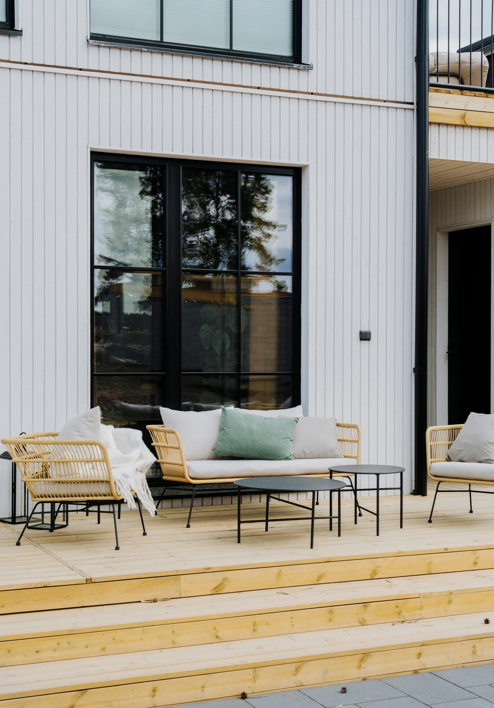 A rattan sofa set placed on a narrow terrace