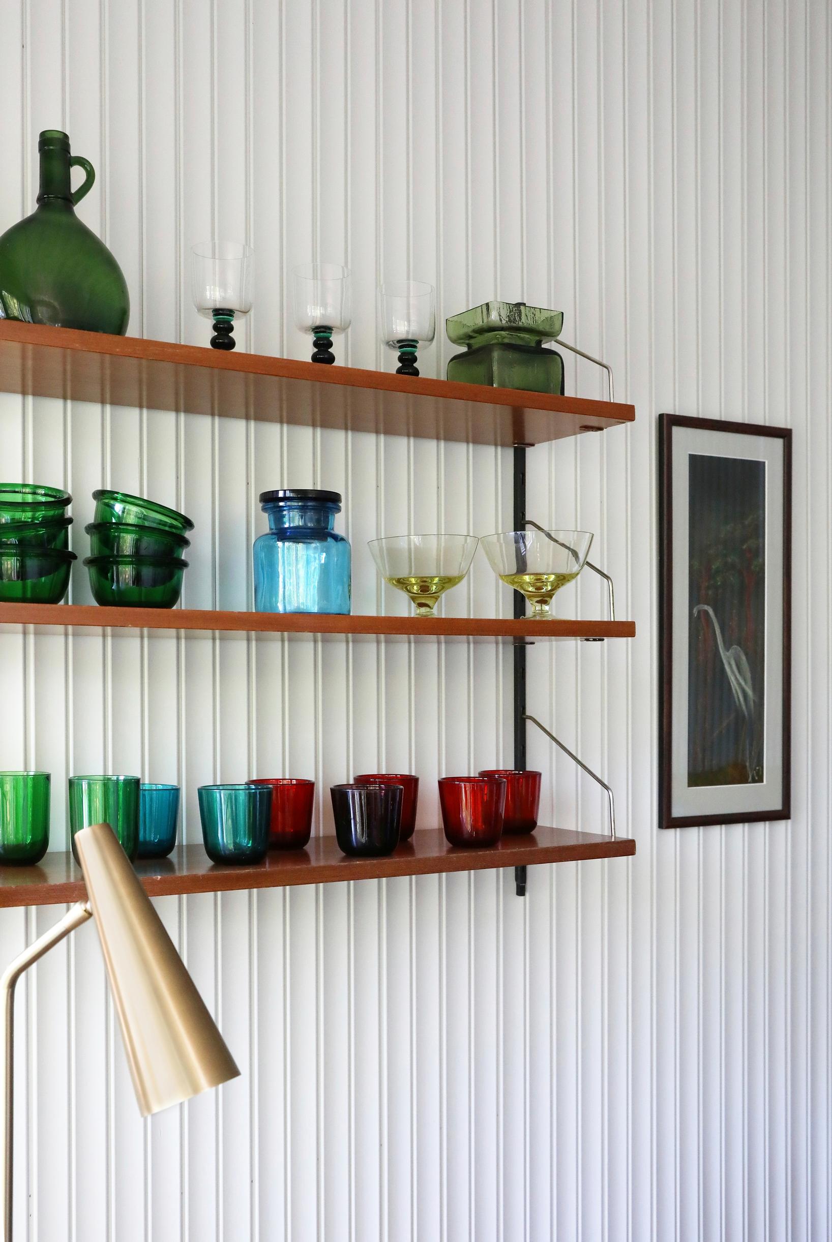 Colorful glassware on a wall shelf