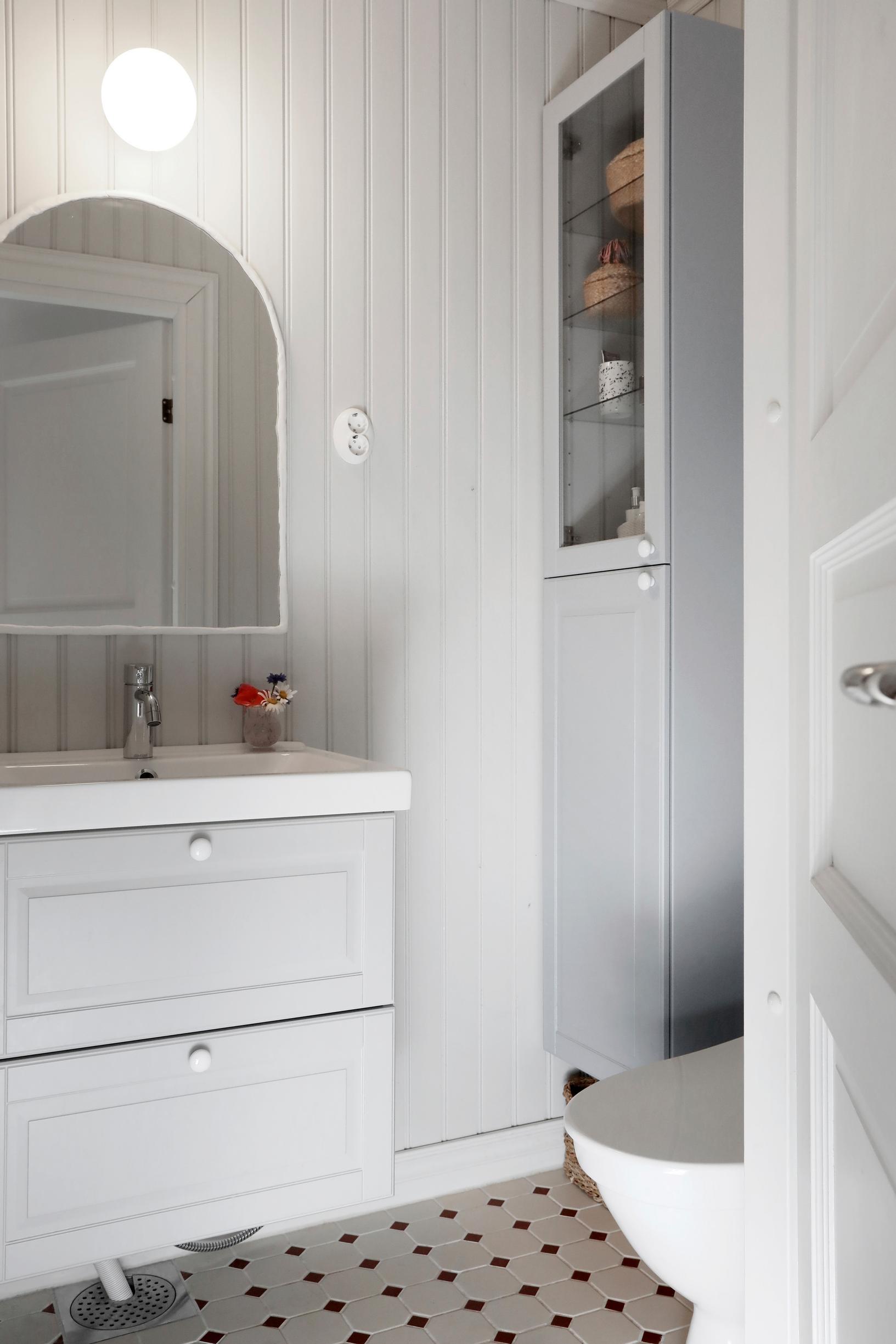 toilet with a curved mirror cabinet