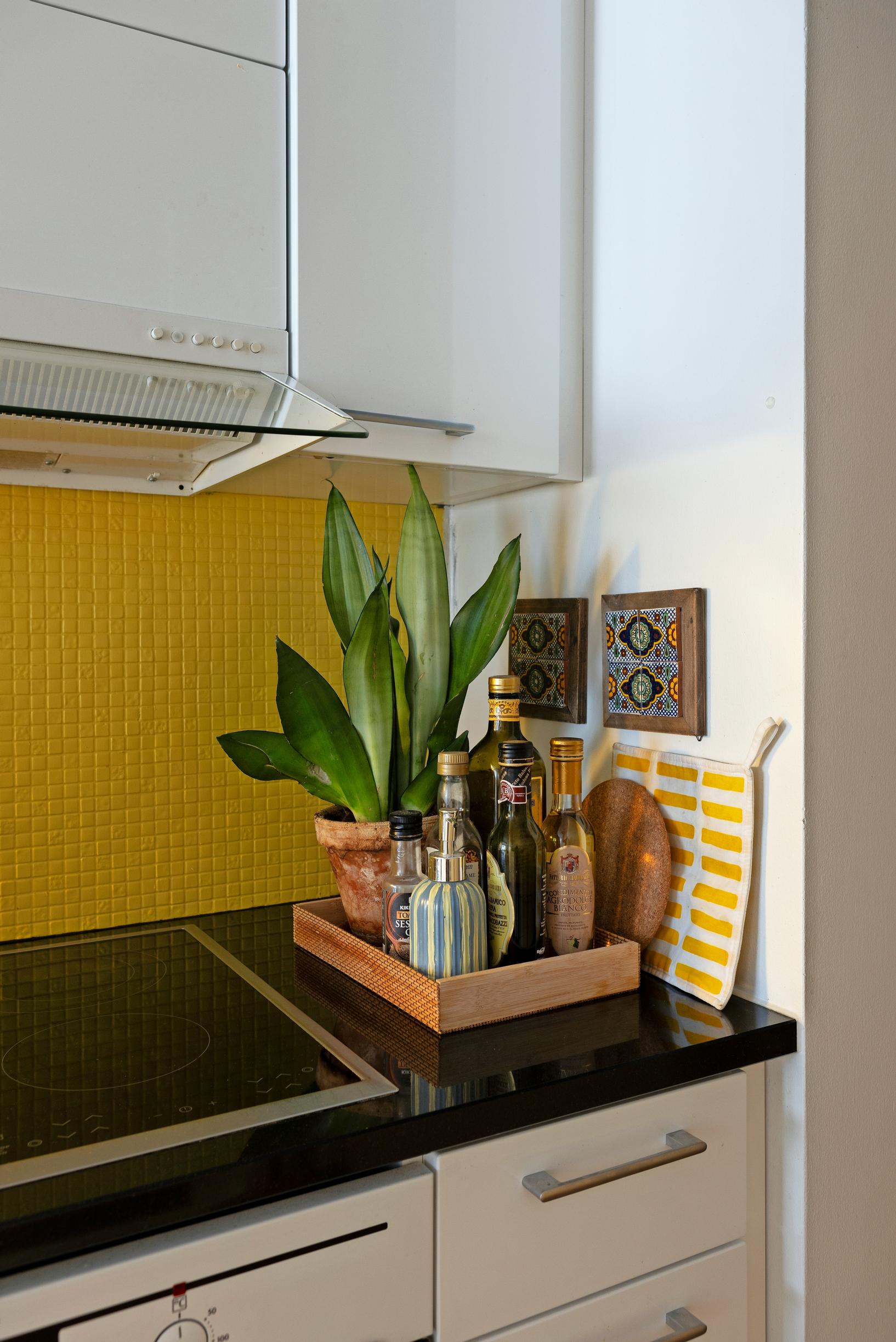 Photo of the kitchen with bright yellow tiles. 