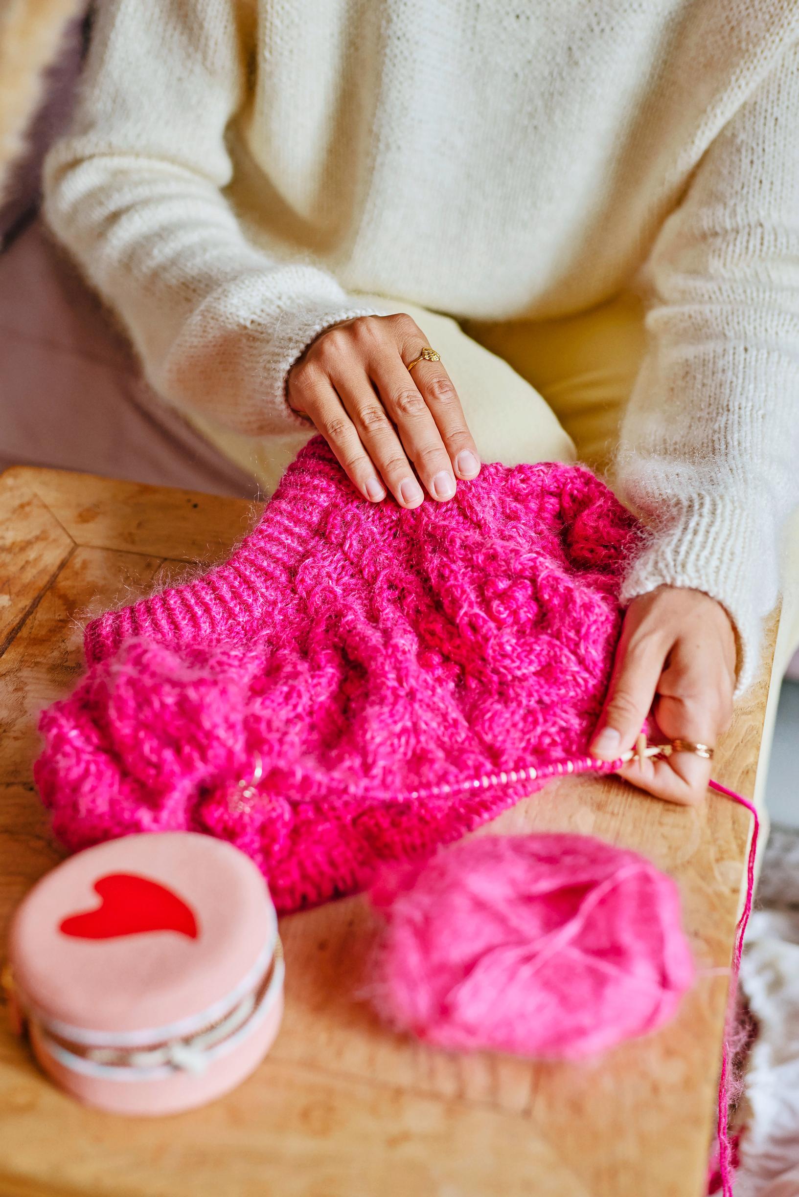 Unfinished pink knitting project on needles