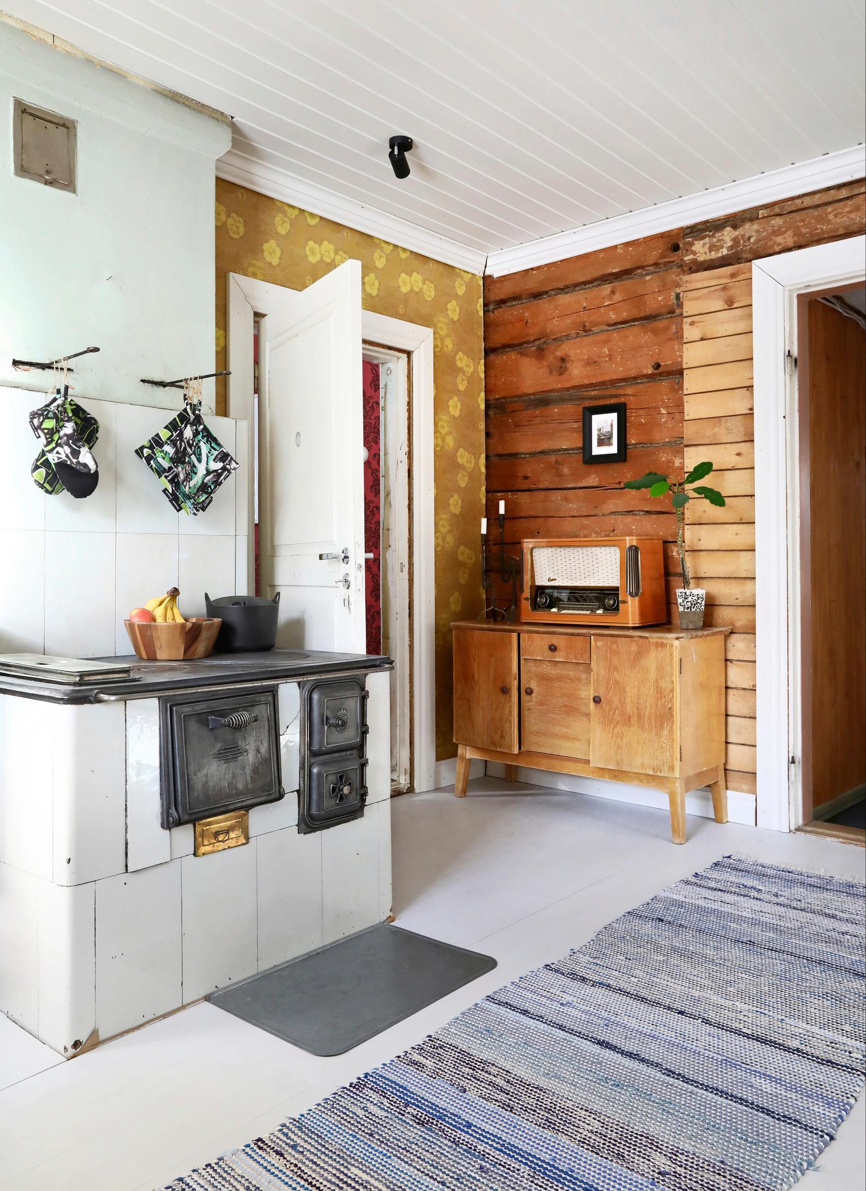 A kitchen featuring a wood-burning stove and a sideboard with a vintage radio