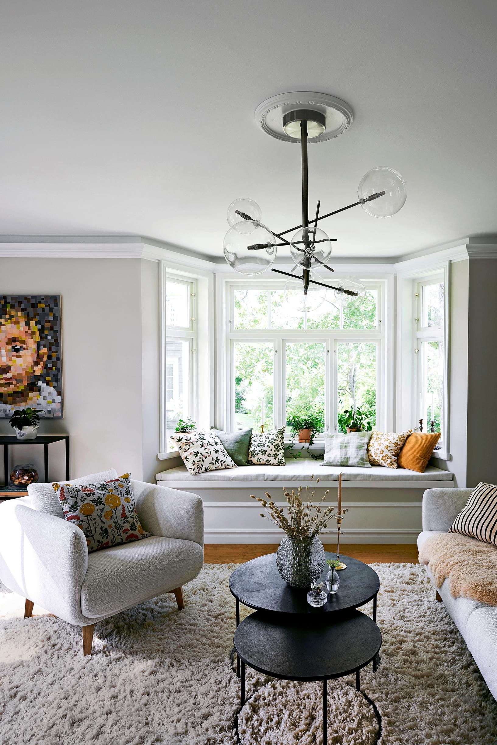 Bay window, plush armchair, and large painting in the living room