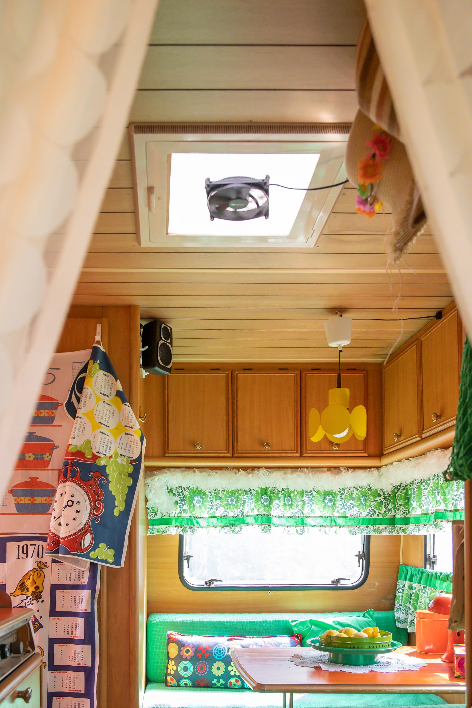 the travel trailer’s roof vent, overhead cabinets, and a sofa nook