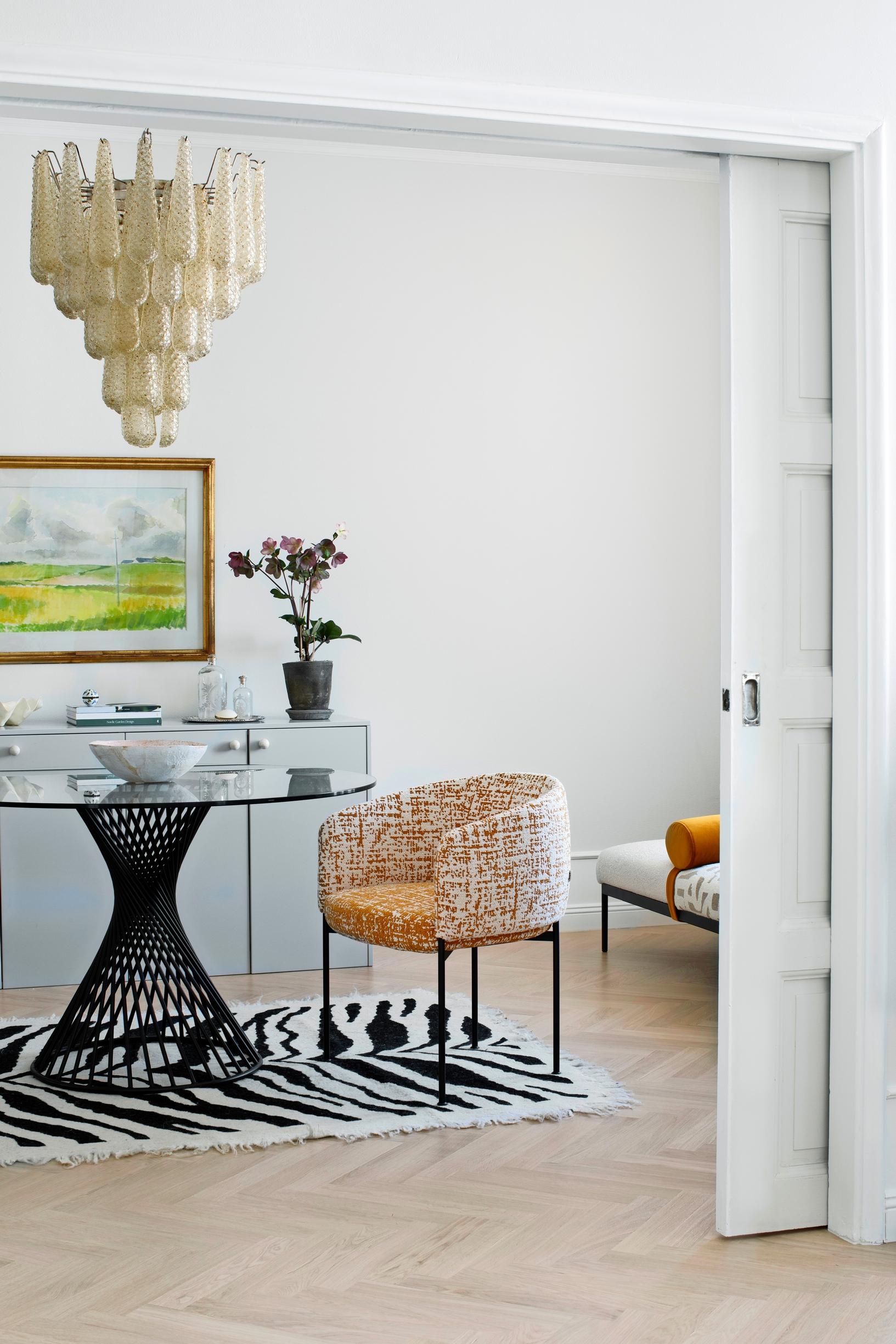 The craft and work room with a round table and zebra-patterned rug.